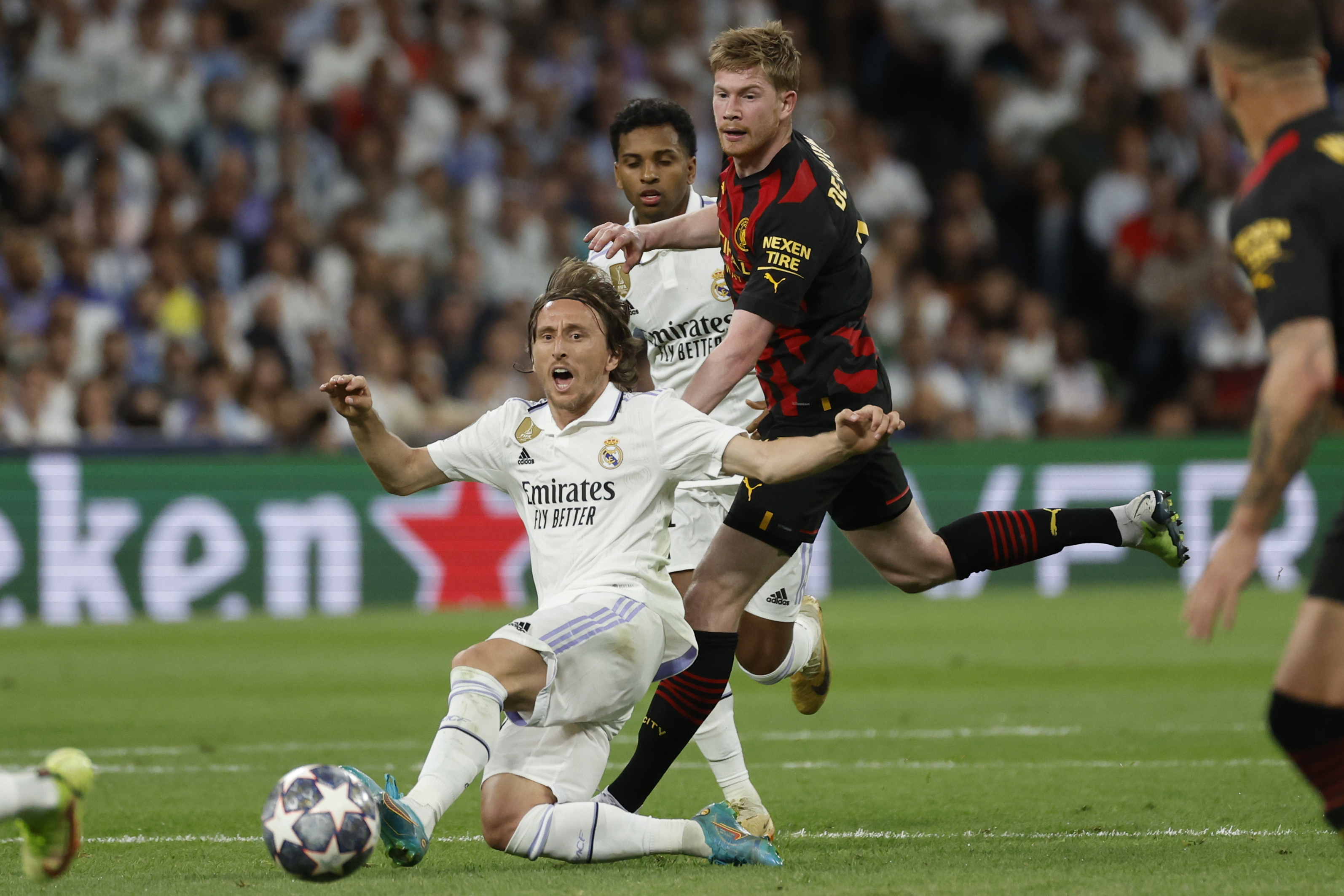 MADRID, 09/05/2023.- El centrocampista croata del Real Madrid Luka Modric (i) cae junto al belga Kevin De Bruyne, del Manchester, durante el partido de ida de las semifinales de la Liga de Campeones que Real Madrid y Manchester City disputan este martes en el estadio Santiago Bernabéu, en Madrid. EFE/Juanjo Martín