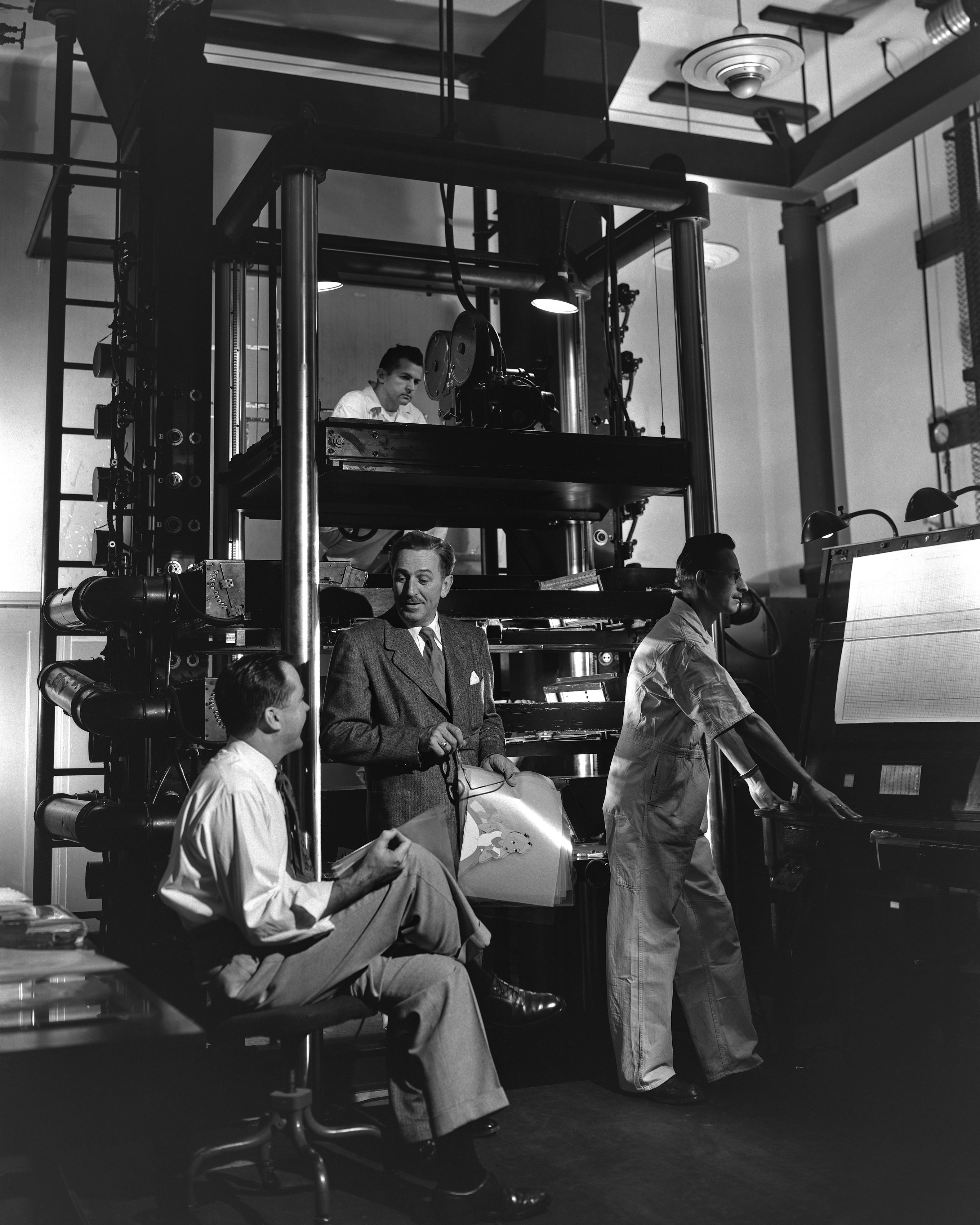 Walt Disney y miembros del personal del Departamento de Cámara del estudio en la cámara multiplano, una innovación que ofrecía una sensación de profundidad y dimensión a las películas animadas, durante la producción de "Alicia en el país de las maravillas" (1951).