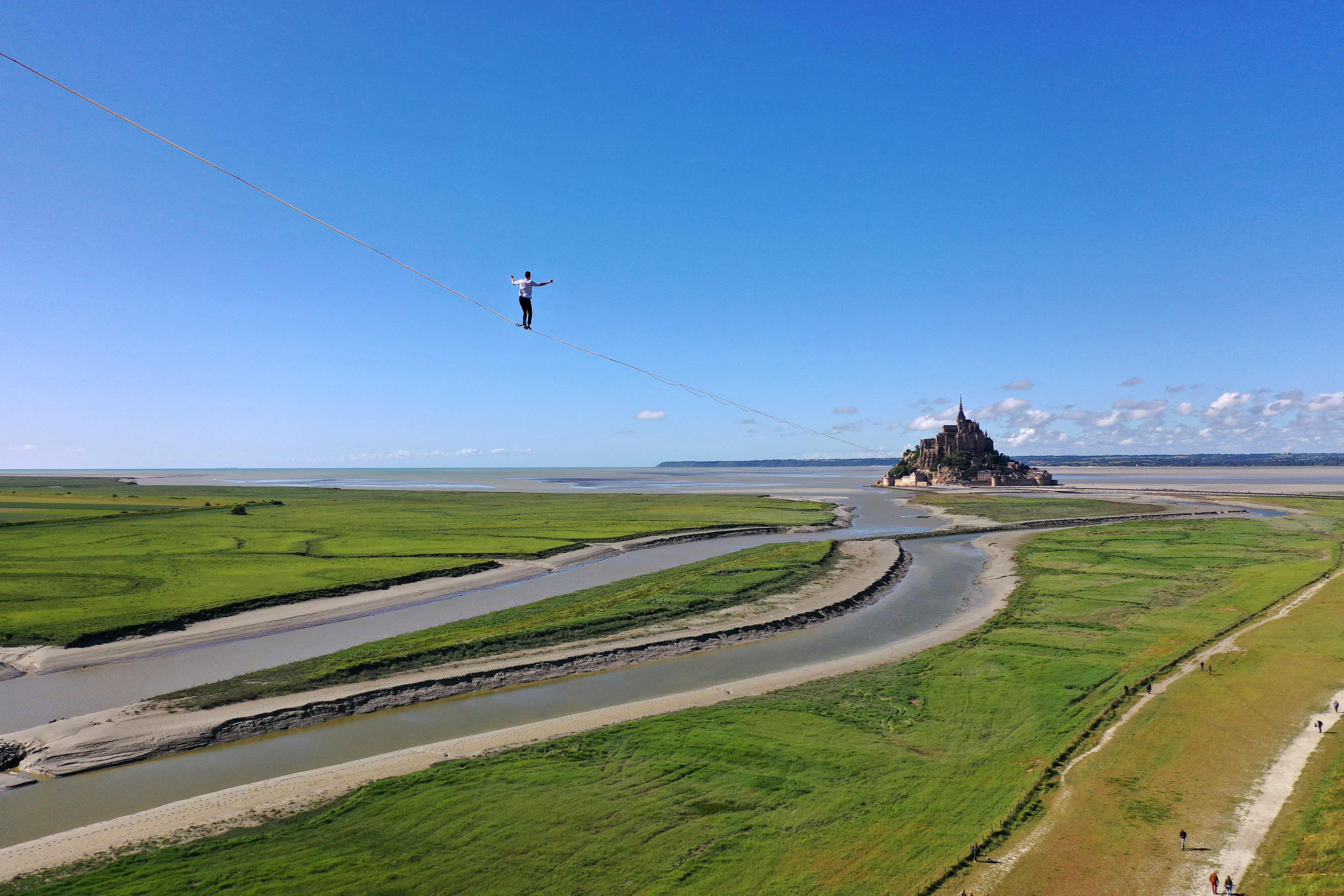 El equilibrista francés Nathan Paulin camina sobre una cuerda floja en la bahía de Le Mont Saint-Michel, en el noroeste de Francia, durante su intento de récord mundial de distancia