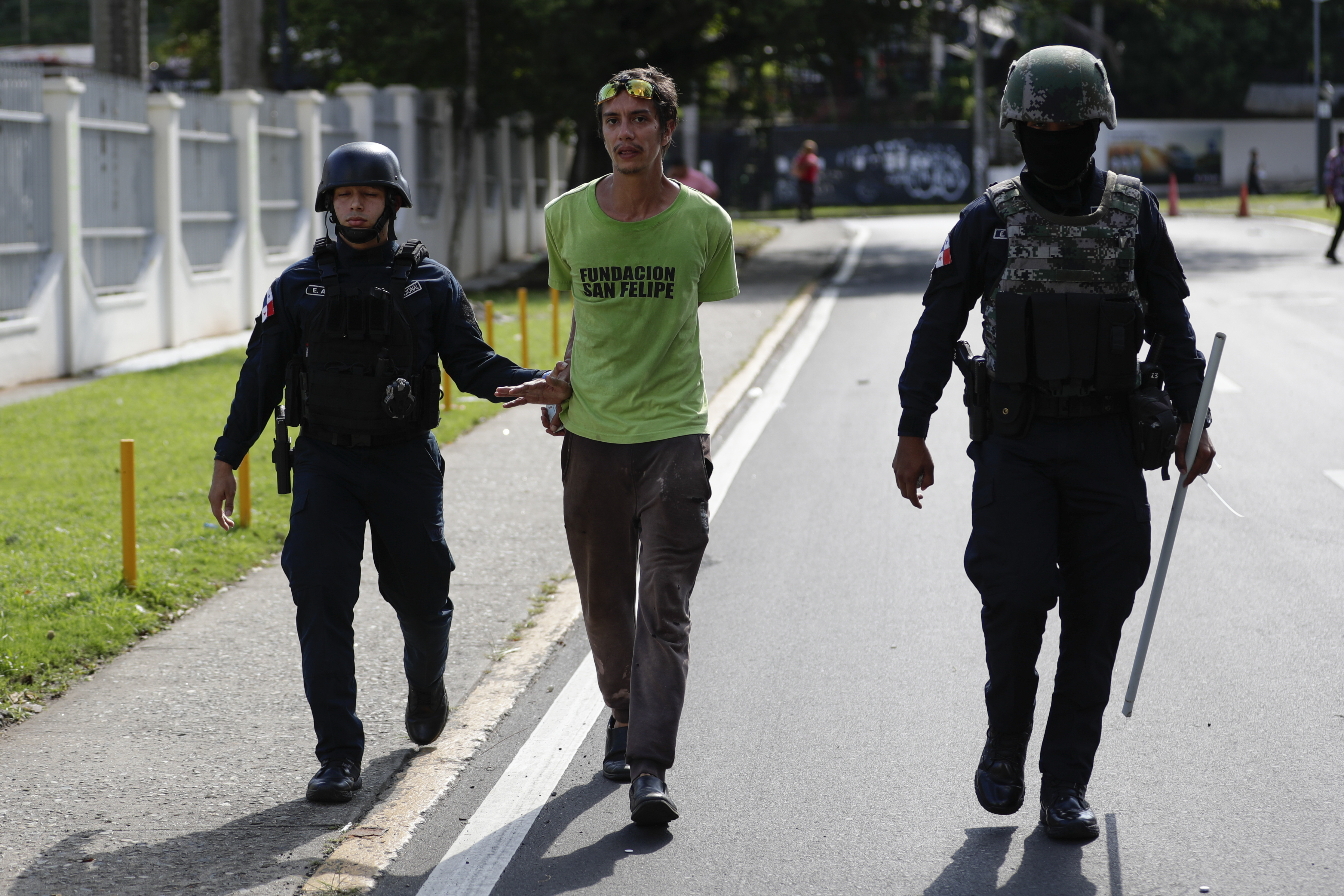 PA2001. CIUDAD DE PANAMÁ (PANAMÁ), 21/11/2023.- Policías antidisturbios detienen hoy a un estudiante de la Universidad de Panamá, durante una nueva jornada de protestas contra la concesión a una filial de la minera canadiense First Quantum Minerals (FQM), en Ciudad de Panamá (Panamá). Al menos 11 estudiantes de la Universidad de Panamá y un reportero gráfico resultaron heridos este martes, presuntamente por disparo de perdigones, durante choques con unidades antidisturbios de la Policía tras un incidente registrado con un automovilista que quedó varado en una de las vías bloqueadas por los universitarios, en medio de las protestas antiminería cerca al centro de estudios, que hoy retomaba las clases presenciales. EFE/Bienvenido Velasco