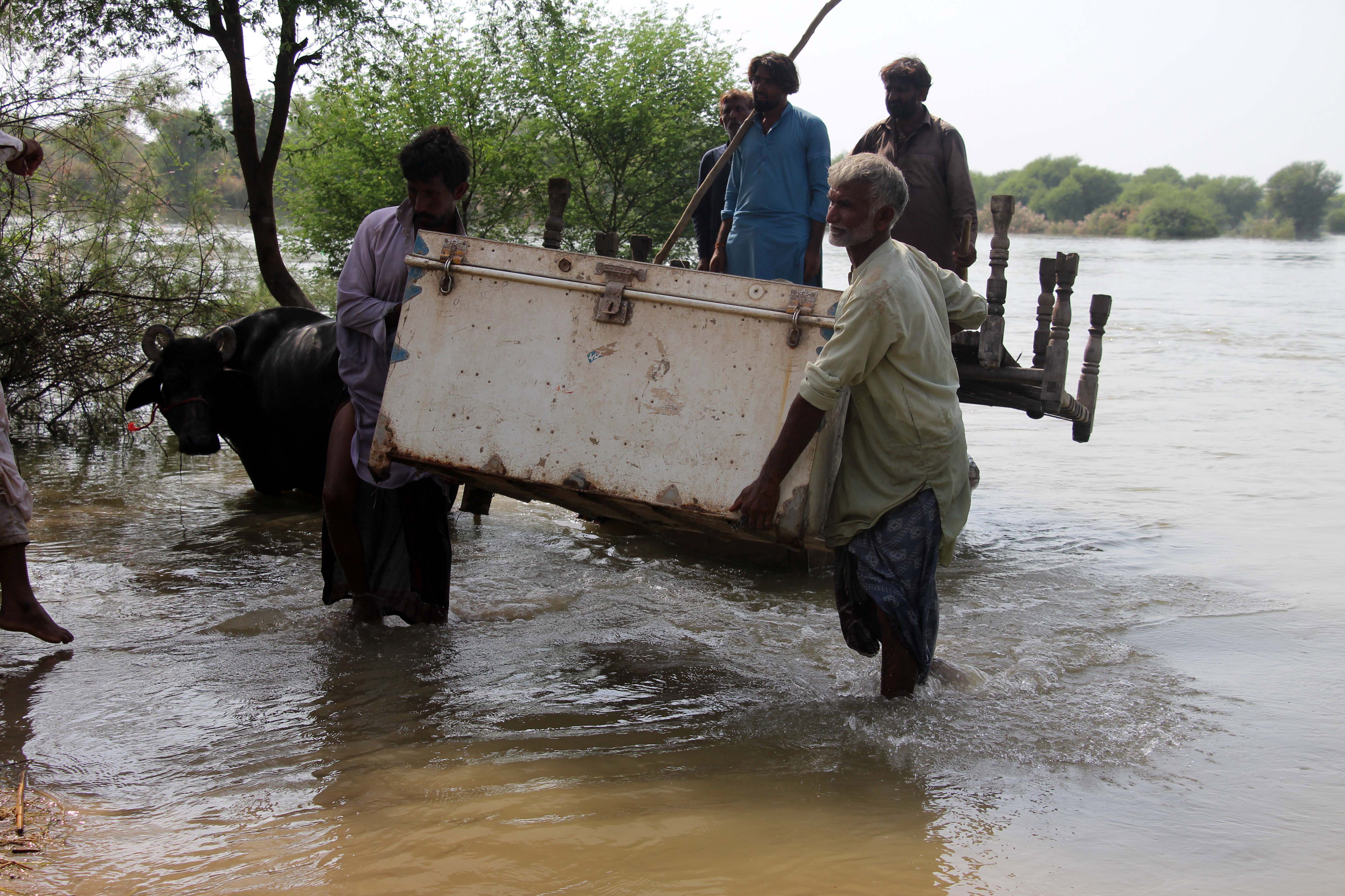 Larkana (Pakistan), 29/08/2022.- People carry furniture through a flooded area following heavy rains in Larkana, Sindh province, Pakistan, 29 August 2022. According to the National Disaster Management Authority (NDMA) on 27 August, flash floods triggered by heavy monsoon rains have killed over 1,000 people across Pakistan since mid-June 2022. More than 33 million people have been affected by floods, the country's climate change minister said. (Inundaciones) EFE/EPA/WAQAR HUSSAIN