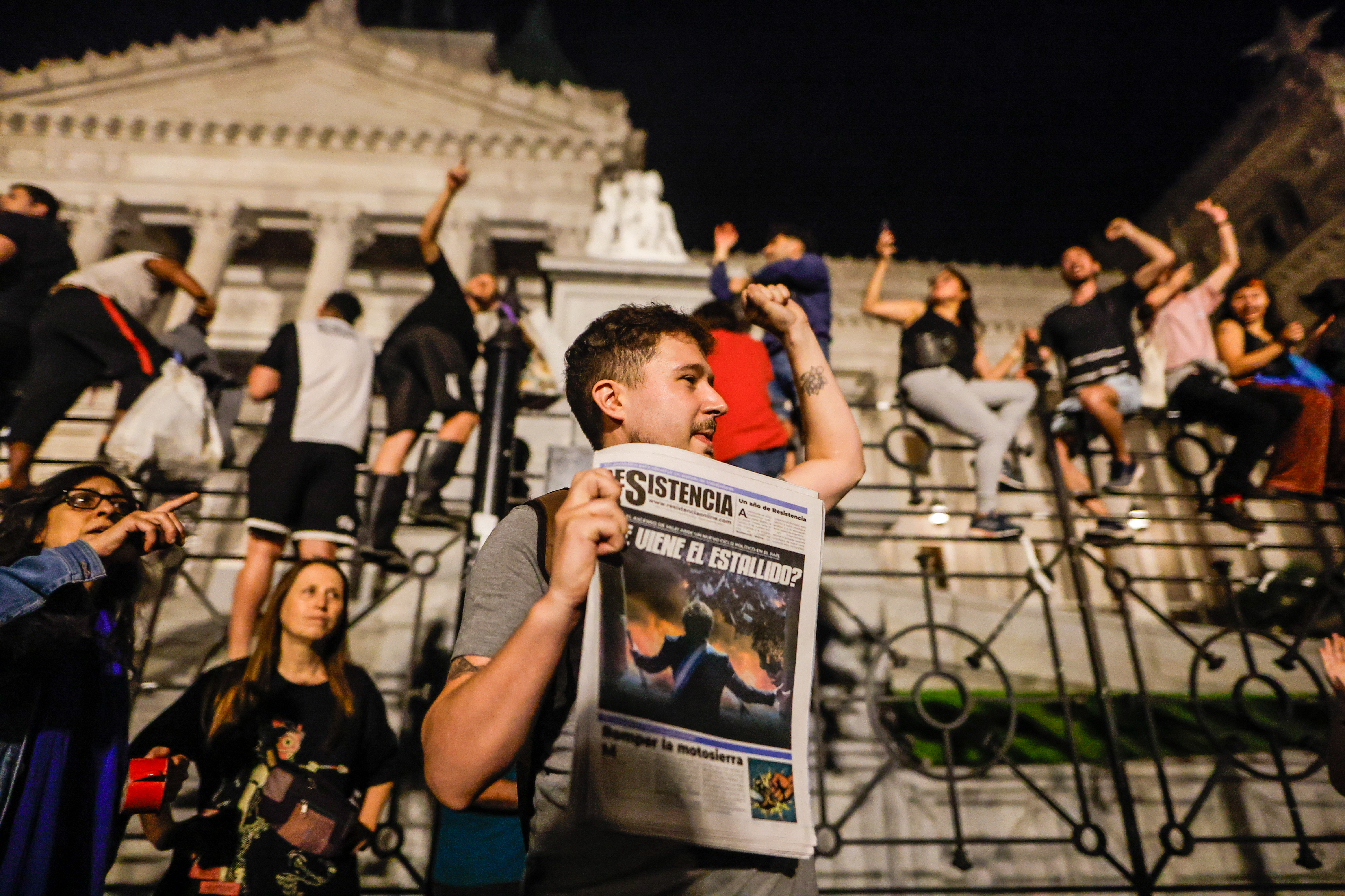 AME5587. CIUDAD DE BUENOS AIRES (ARGENTINA), 21/12/2023.- Varias personas participan en una manifestación contra las medidas anunciadas por el presidente Javier Milei, que empezó en la noche de este miércoles y se extendió hasta la madrugada de hoy, frente al Congreso de la Nación en Buenos Aires (Argentina). El ultraliberal Javier Milei anunció un programa de estabilización con el que aspira reconstruir la economía terminando con el endémico déficit fiscal. Después de que Milei anunciara este plan, cientos de manifestantes se concentraron en las inmediaciones de la sede del Congreso de la Nación para continuar con la protesta que horas antes habían llevado a cabo unas tres mil personas que recorrieron las calles del centro de Buenos Aires para finalizar concentrándose en la emblemática Plaza de Maya, frente a la Casa Rosada, sede de la Presidencia de la República. EFE/ Juan Ignacio Roncoroni