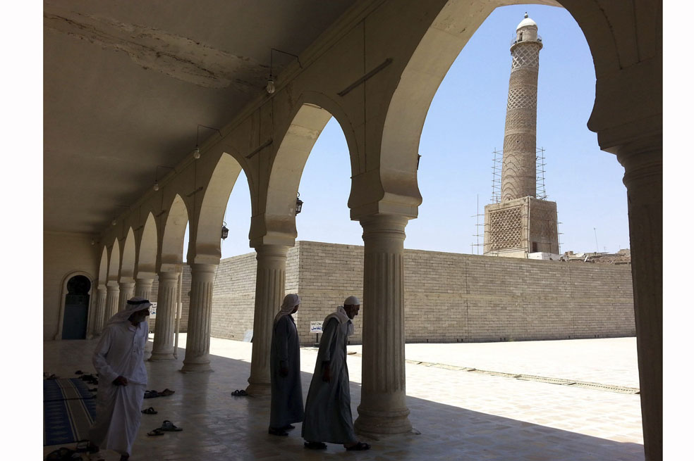 Dos hombres salen de la mezquita de Al-Noori Al-Kabeer, en la que ondeaba una bandera del grupo yihadista Estado Islámico (EI) en Mosul, al norte de Irak. / EFE