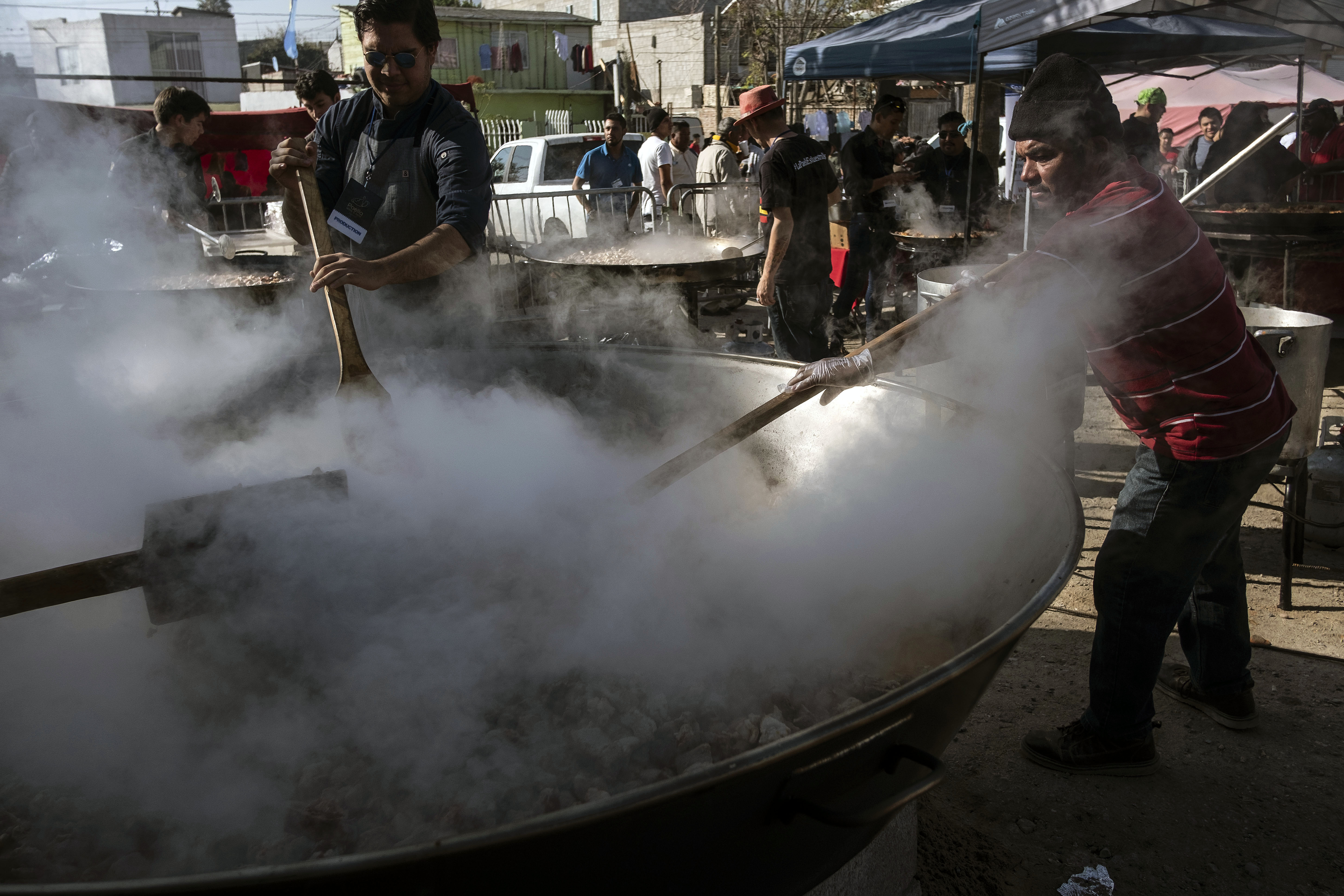 Chefs internacionales cocinan paella para miles de migrantes en Tijuana