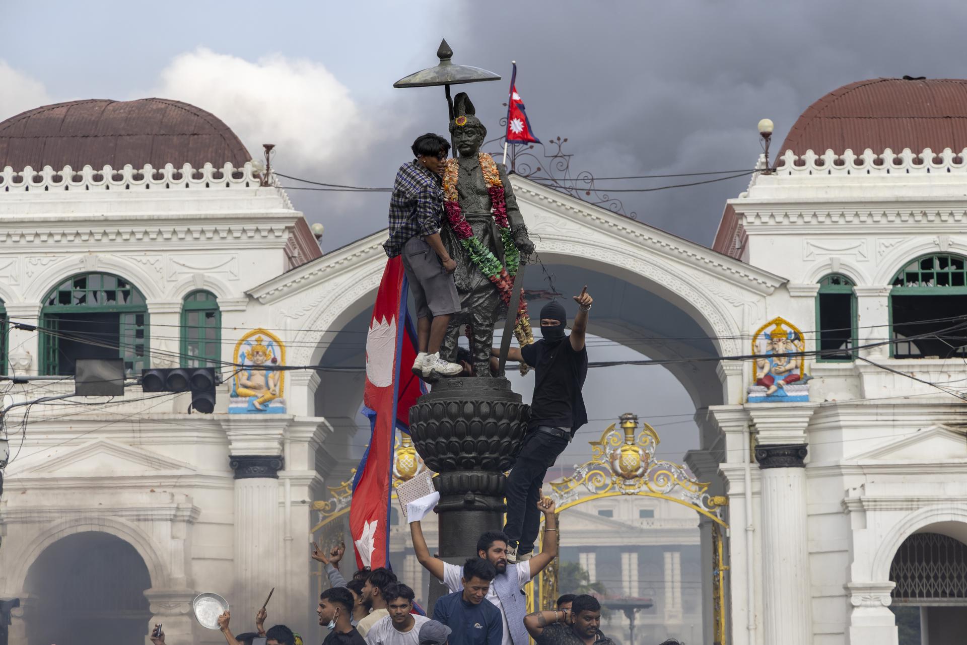 Kathmandu (Nepal), 09/09/2025.- Protesters install the national flag on the statue of Nepal's first king, Prithvi Narayan Shah during violent demonstrations in Kathmandu, Nepal, 09 September 2025. At least 19 people were killed and dozens injured on 08 September during demonstrations against corruption and a government social media ban. (Protestas) EFE/EPA/NARENDRA SHRESTHA