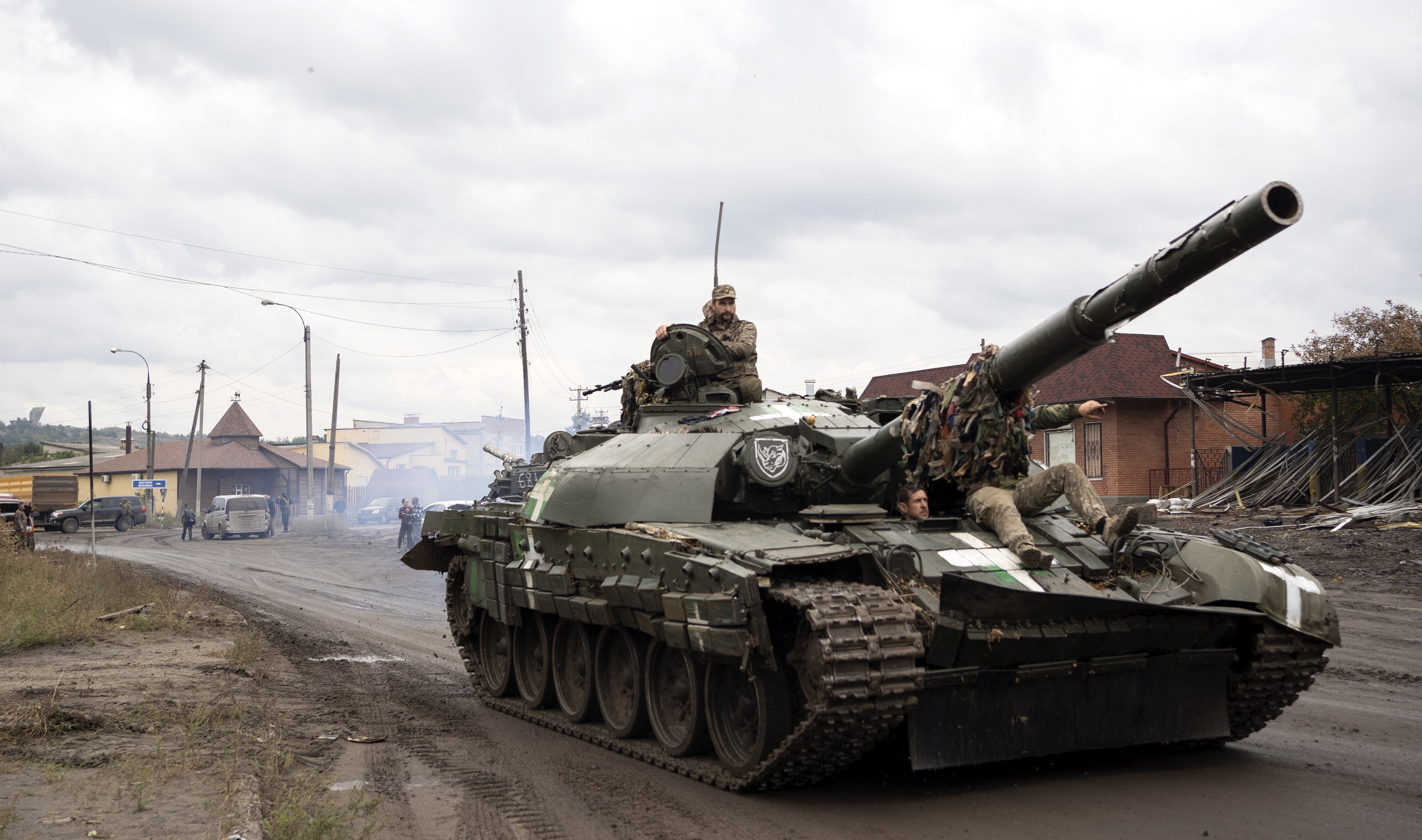 Militares ucranianos pasan sobre un tanque en la ciudad recuperada de Izyum. Para su sorpresa, el ejército ucraniano ha podido apropiarse de cientos de materiales de guerra en perfecto estado que las tropas rusas dejaron abandonados.