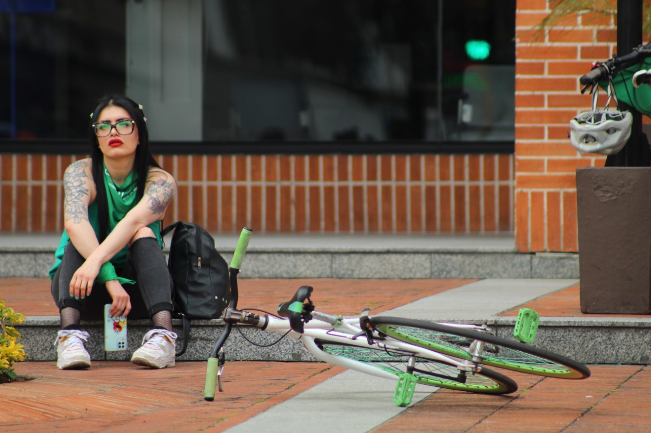 Una mujer sentada al lado de una bicicleta