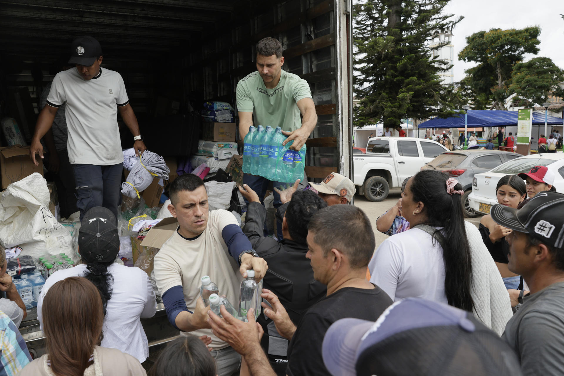ACOMPAÑA CRÓNICA: COLOMBIA TERREMOTO AME9844. EL CAIRO (COLOMBIA), 17/08/2026.- Fotografía del 15 de agosto de 2026 que muestra un grupo de voluntarios entregando ayudas humanitarias, en El Cairo (Colombia). Las carreteras del centro-oeste de Colombia, la zona más afectada por el terremoto de magnitud 7,4 del pasado 10 de agosto, están llenas de vehículos particulares y camiones con letreros que dicen 'Ayuda humanitaria', una iniciativa de ciudadanos que recorren cientos de kilómetros para ayudar a los damnificados. EFE/ Carlos Ortega
