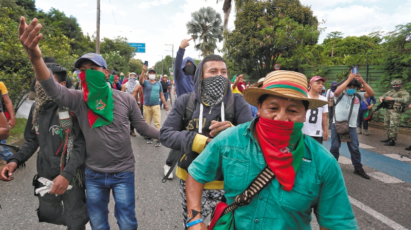 AME6417. CALI (COLOMBIA), 09/05/2021.- IndÌgenas caminan por una calle durante una manifestaciÛn hoy en Cali (Colombia). Varias autoridades denunciaron que este domingo supuestos civiles armados dispararon contra un grupo de indÌgenas que estaban manifest·ndose a las afueras de la ciudad colombiana de Cali, dejando varios heridos. EFE/ Pablo RodrÌguez