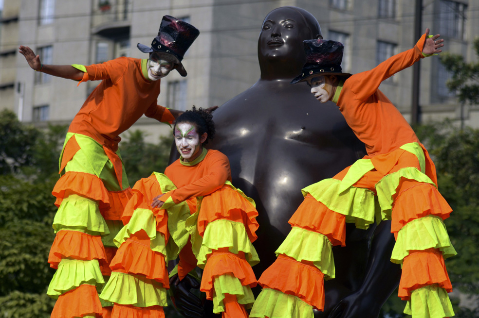Artistas colombianos posan junto a una escultura del escultor colombiano Fernando Botero, durante la inauguración del Festival de Artes Escénicas en las calles de Medellín, Antioquia.
