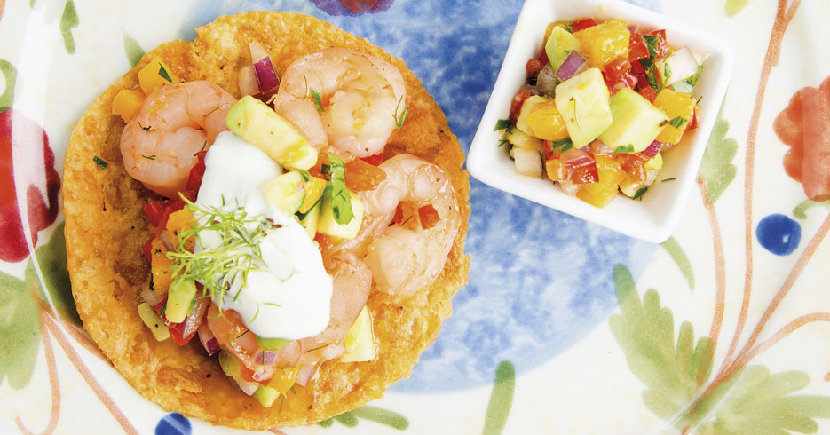 Langostinos asados con miel y pico de gallo con mango sobre tostada de plátano