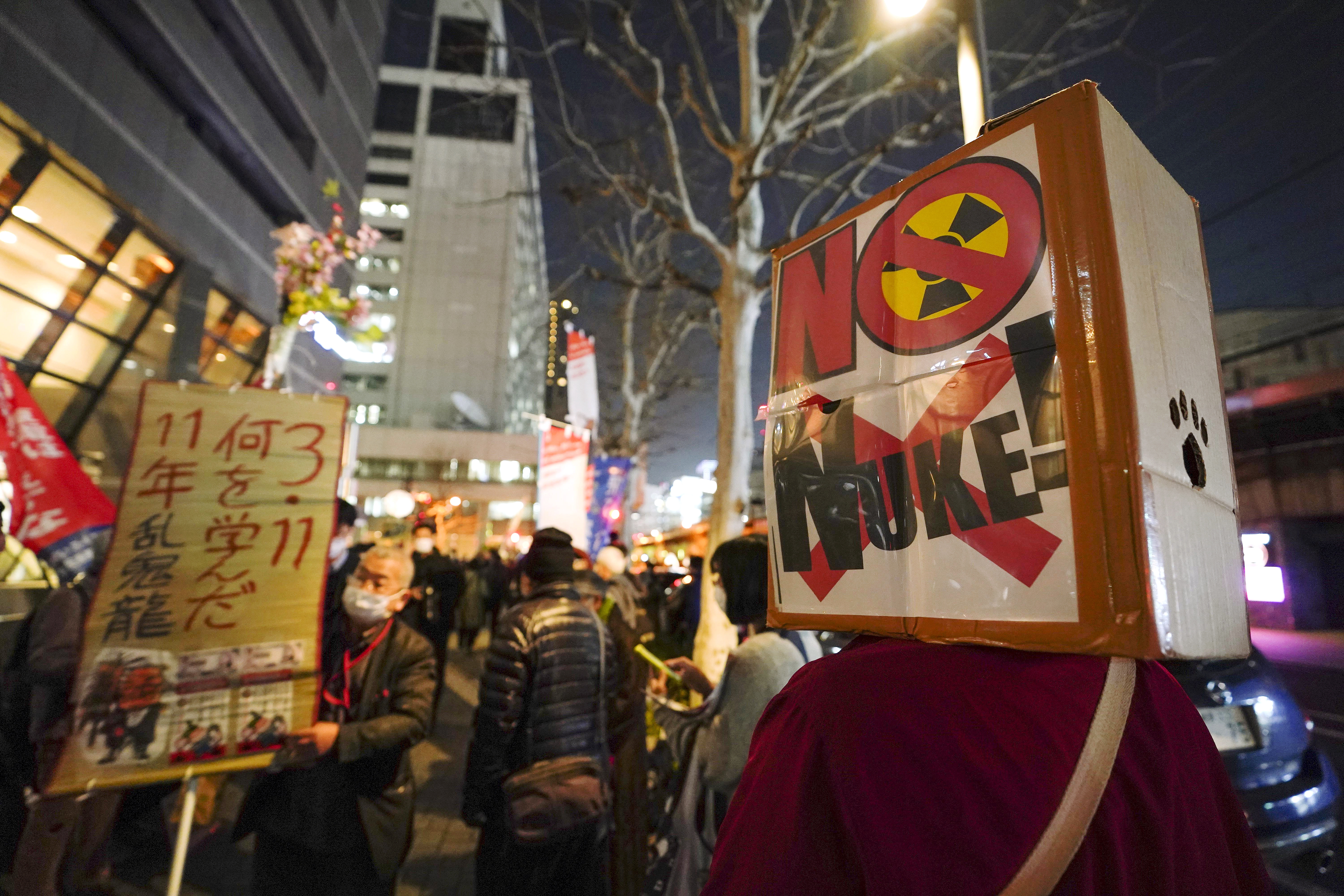 Tokyo (Japan), 11/03/2022.- Demonstrators protest against nuclear power plant and flushing radioactive contaminated water into the sea in front of Tokyo Electric Power Company (TEPCO) headquarters (Rear Center) in Tokyo, Japan, 11 March 2022, marking the 11th anniversary of the magnitude 9.0 earthquake and tsunami devastating TEPCO's Fukushima Daiichi Nuclear Power Plant in 2011. According to the National Police Agency, 15,900 people have died and 2,523 are still missing in Fukushima, Miyagi and Iwate Prefectures by the earthquake and tsunami. The banner reads 'Don't flush radioactive contaminated water into the sea.' (Terremoto/sismo, Protestas, Japón, Tokio) EFE/EPA/KIMIMASA MAYAMA