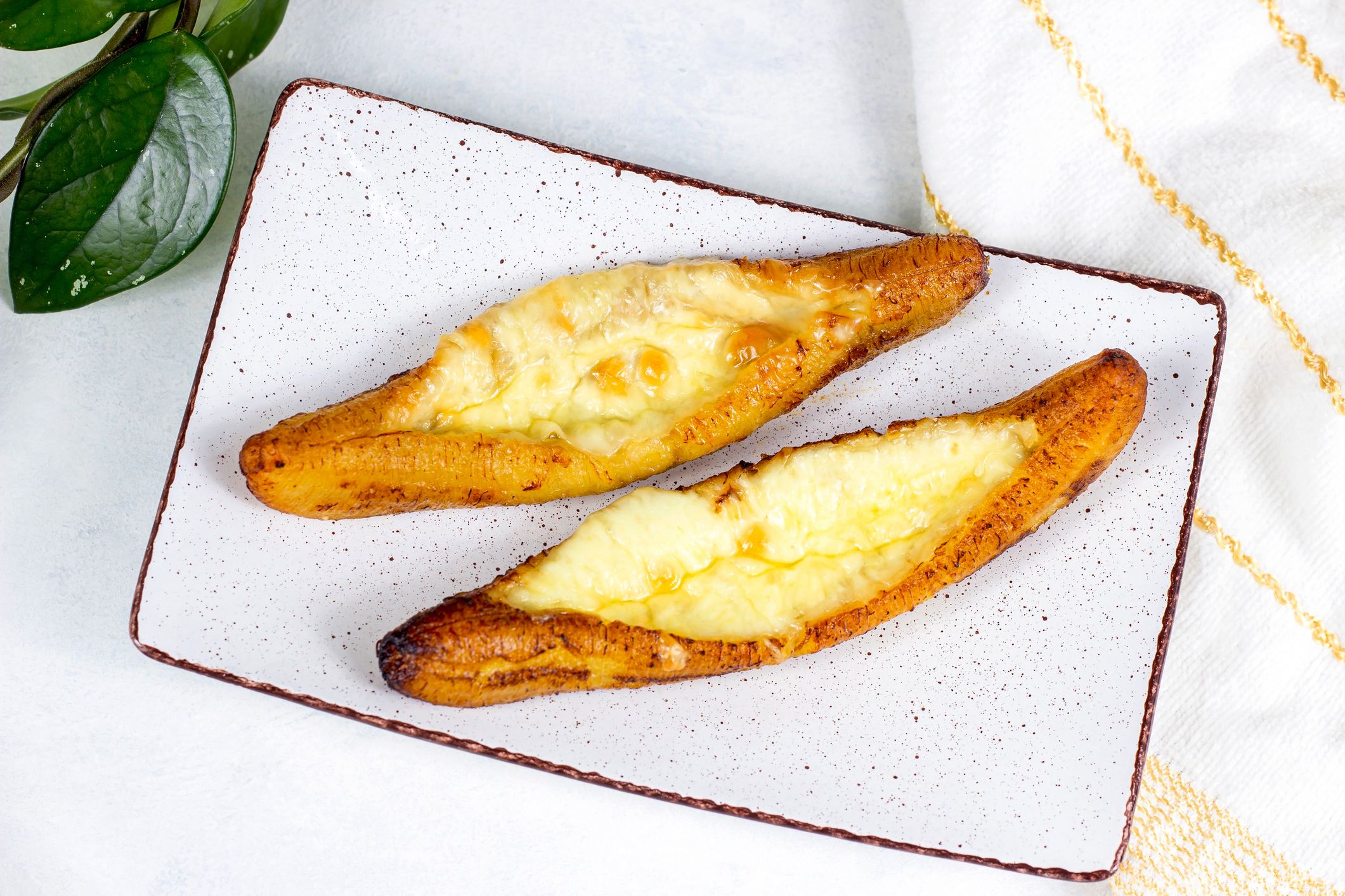 Plátano maduro gratinado relleno de salchicha con salsa BBQ