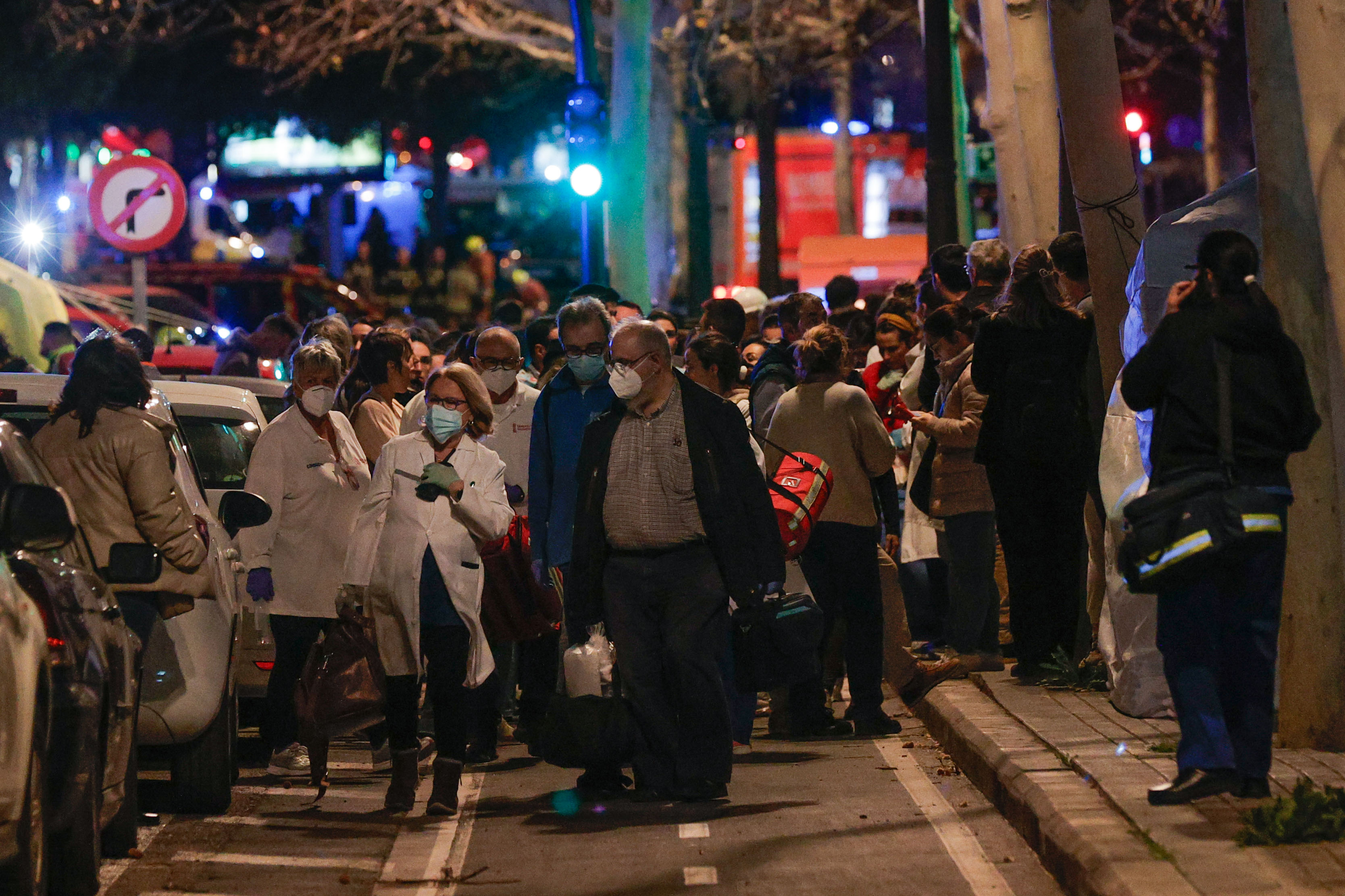VALENCIA, 22/02/2024.- Vecinos son atendidos durante el incendio declarado sobre las cinco y media de esta tarde en un quinto piso de un edificio de viviendas de València que ha afectado totalmente al inmueble y se ha propagado a otro anexo, y los bomberos intentan aún rescatar a vecinos desde los balcones. EFE/Manuel Bruque