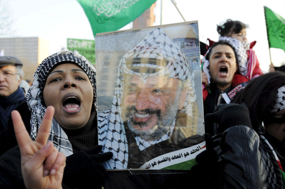 Una mujer sostiene una fotografía del fallecido líder palestino Yasir Arafat durante una manifestación contra la ofensiva israelí sobre Gaza en Berlín, Alemania en enero de 2009