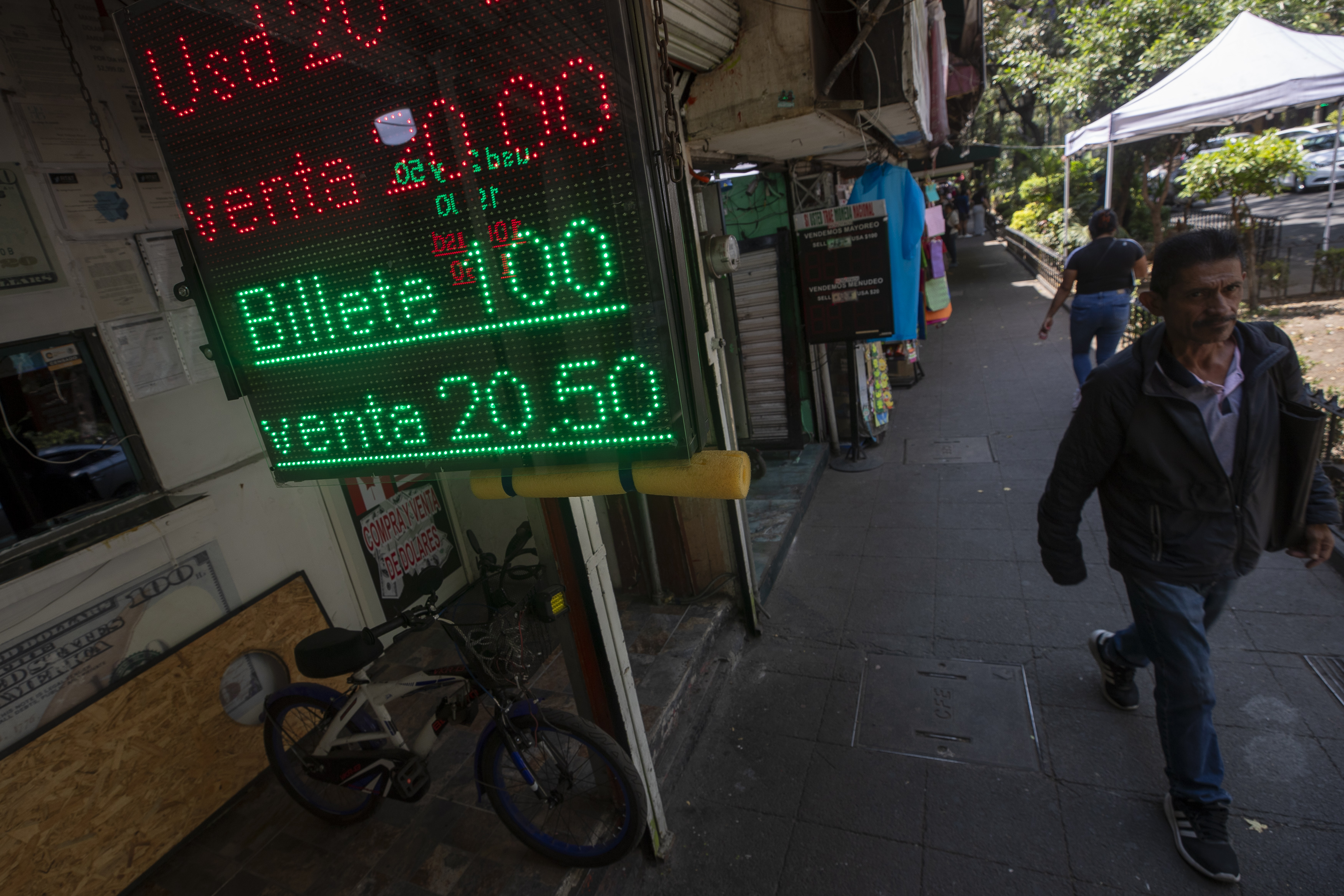 MEX8491. CIUDAD DE MÉXICO (MÉXICO), 05/04/2025.- Personas caminan frente a una casa de cambio este miércoles, en Ciudad de México (México). La relación de América Latina con el dólar estadounidense es diversa y, en muchos casos, contradictoria. Mientras algunos países han adoptado formalmente la divisa como moneda de curso legal, otros viven en un régimen de bimonetarismo de facto, donde el dólar reina en la economía cotidiana sin figurar oficialmente. EFE/ Isaac Esquivel