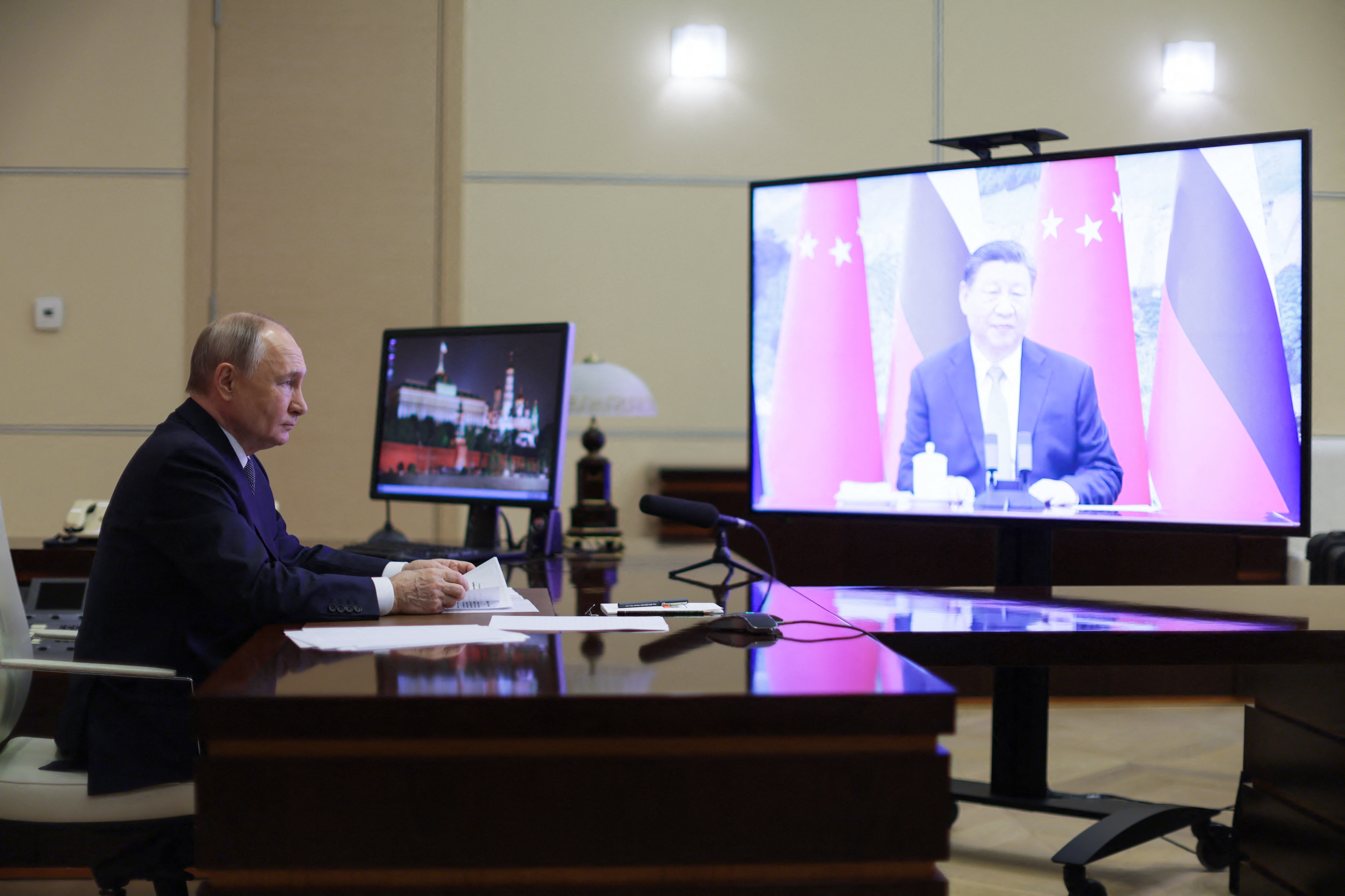 In this pool photograph distributed by the Russian state agency Sputnik, Russia's President Vladimir Putin holds a videocall with Chinese President Xi Jinping at the Novo-Ogaryovo state residence outside Moscow on January 21, 2025. (Photo by Gavriil Grigorov / POOL / AFP)