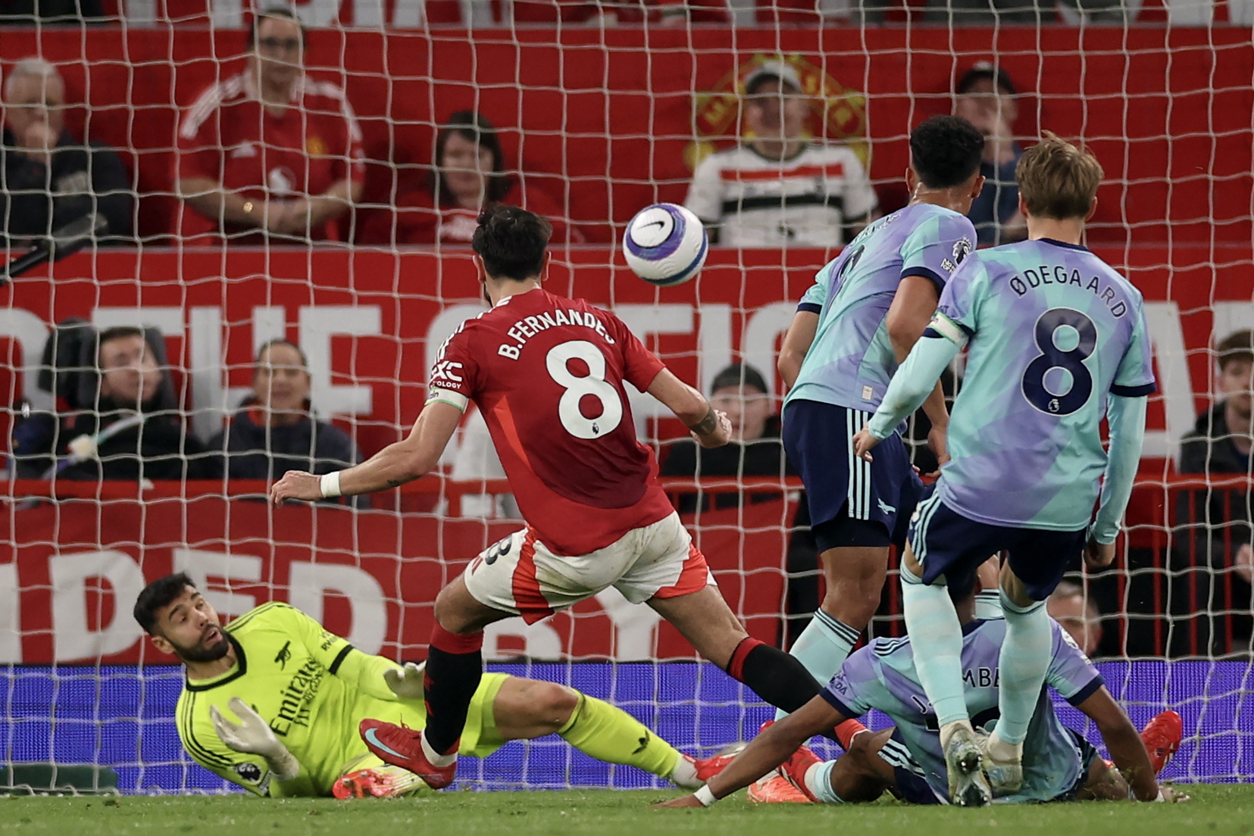 MANCHESTER (United Kingdom), 09/03/2025.- Bruno Fernandes (C) of Manchester United in action against goalkepeer David Raya (L) of Arsenal during the English Premier League match between Manchester United and Arsenal FC, in Manchester, Britain, 09 March 2025. (Reino Unido) EFE/EPA/ADAM VAUGHAN EDITORIAL USE ONLY. No use with unauthorized audio, video, data, fixture lists, club/league logos, 'live' services or NFTs. Online in-match use limited to 120 images, no video emulation. No use in betting, games or single club/league/player publications.