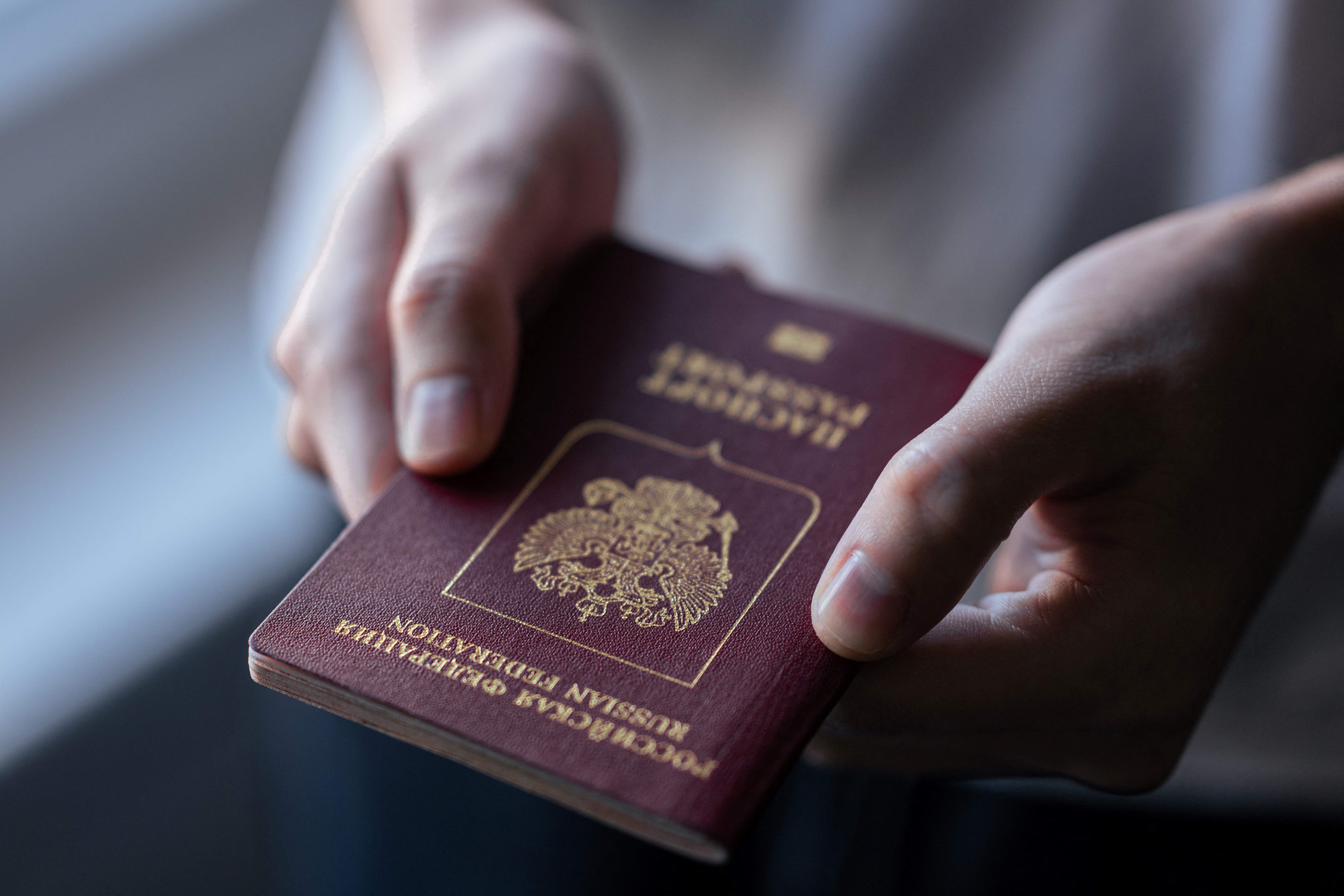 (FILES) Konstantin, 26 years old from Russia, holds his passport during an interview with AFP in Belgrade on February 1, 2024.