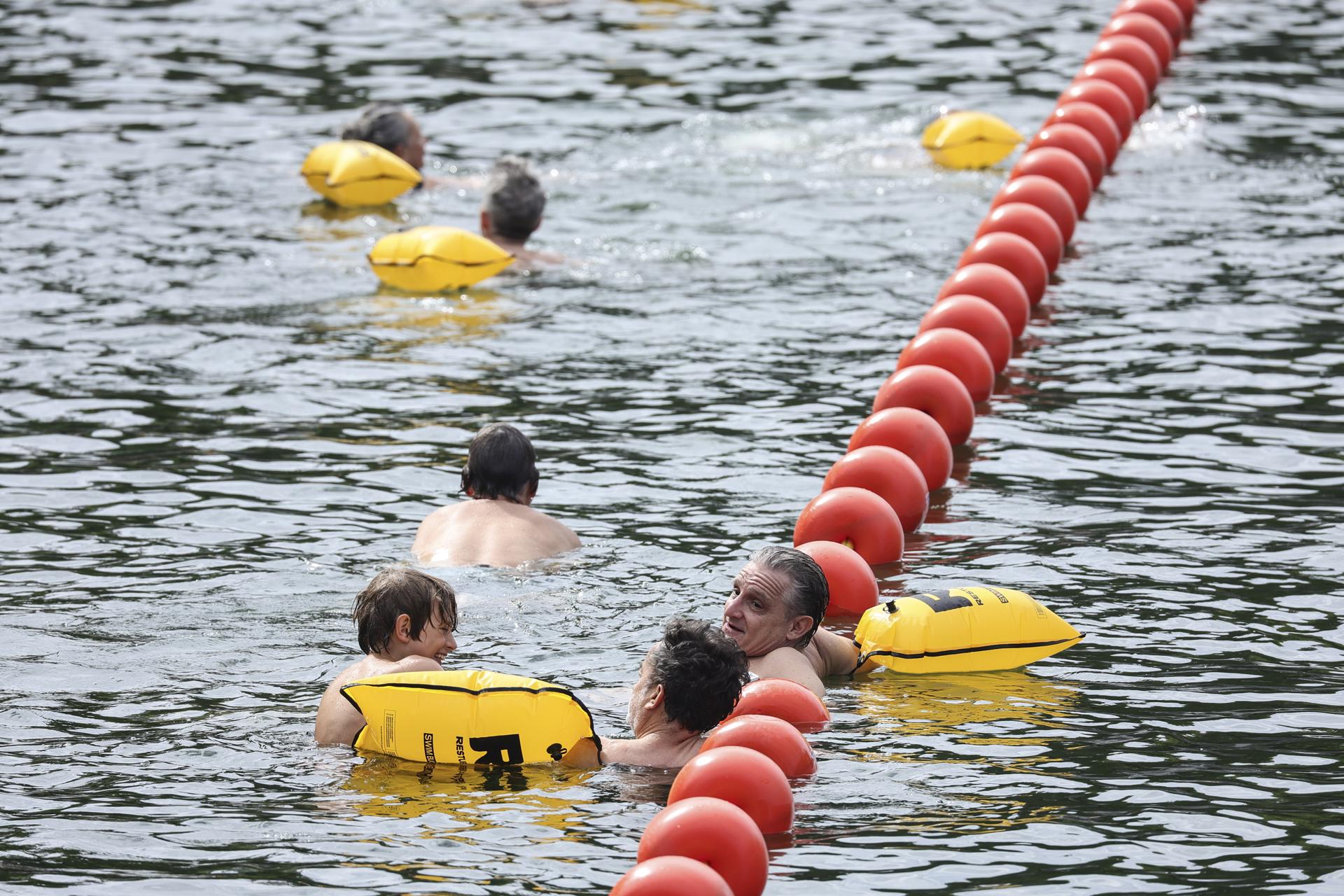 Paris (France), 05/07/2025.- People swim near the Pont Marie, one of the three safe swimming areas that opened to the public on the Seine River, in Paris, France, 05 July 2025. From 05 July to 31 August 2025, people will be able to swim in three safe swimming areas on the Seine river, an activity that has been banned since 1923. (Francia) EFE/EPA/TERESA SUAREZ