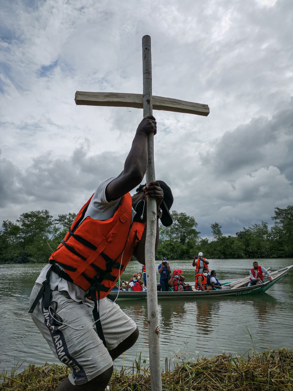 un hombre joven, entierra una cruz de madera en la tierra