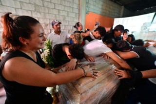 Football teammates of Ismael Arroyo, 15, mourn around his coffin during his wake and that of his brother Josue, 14, two of the four minors who had been missing for three weeks since disappearing during a military operation while playing football, in Guayaquil, Ecuador, on January 1, 2025.