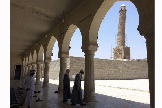 Dos hombres salen de la mezquita de Al-Noori Al-Kabeer, en la que ondeaba una bandera del grupo yihadista Estado Islámico (EI) en Mosul, al norte de Irak. / EFE