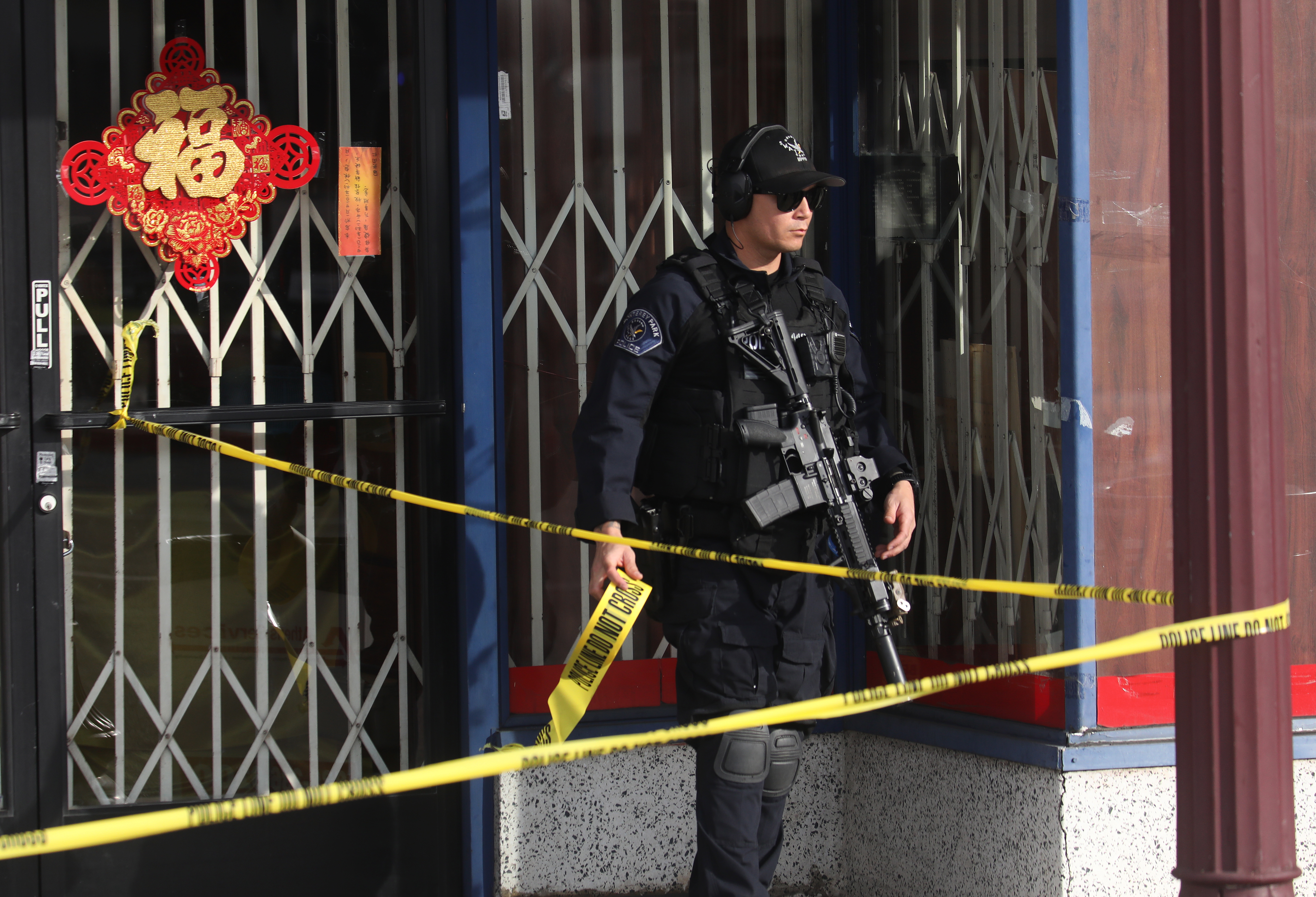 Monterey Park (United States), 22/01/2023.- A Monterey Park Police officer with crime scene tape after a mass shooting at a dance studio in Monterey Park, California, USA, 22 January 2023. The shooting killed ten and wounded ten more during a Lunar New Year celebration according to the Los Angeles County Sheriff's Department. (Estados Unidos) EFE/EPA/DAVID SWANSON