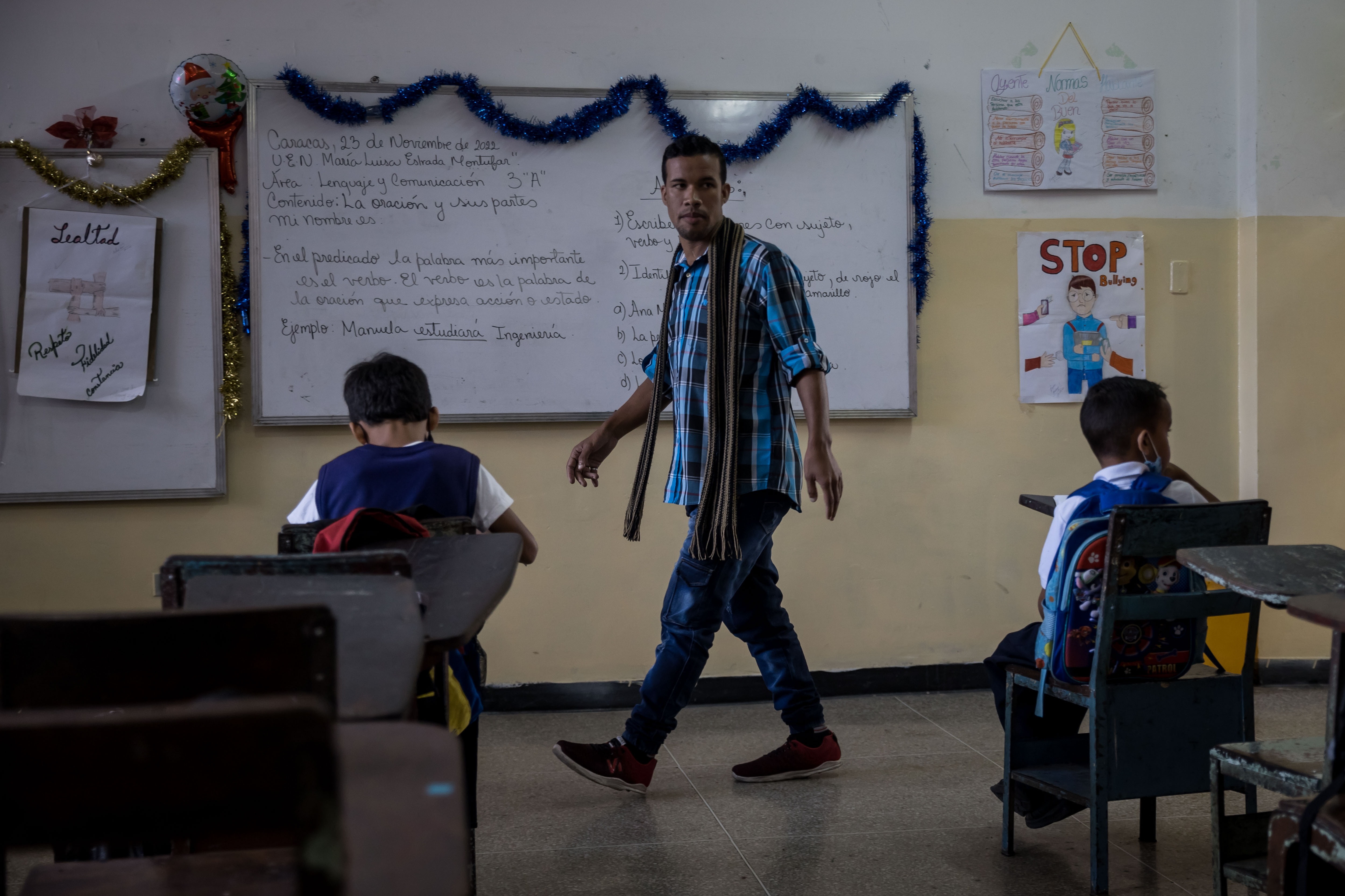 AME872. CARACAS (VENEZUELA), 15/12/2022.- Yerrison Barrios, un maestro de primaria de 28 años de edad, dicta clase en una escuela pública, el 23 de noviembre de 2022, en Caracas (Venezuela). El Gobierno de Venezuela abonó este jueves a los trabajadores públicos el cuarto pago de las utilidades, un beneficio de fin de año que se redujo como consecuencia de la devaluación de la moneda local -el bolívar- frente al dólar, que solo en lo que va de diciembre se ha depreciado en un 27 %. EFE/ Miguel Gutiérrez