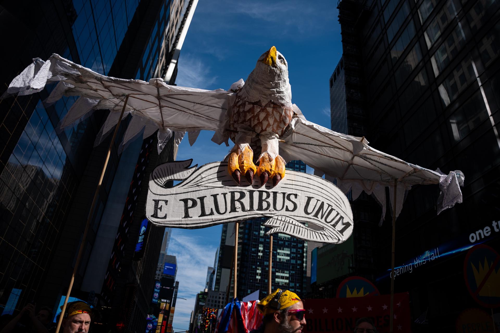 Una marioneta de papel en forma de ave sostiene el lema de Estados Unidos, “E Pluribus Unum” (“De muchos, uno”), durante la protesta “No Kings” en Nueva York.
