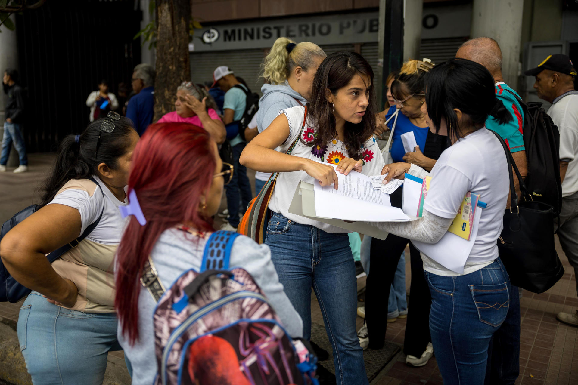 AME5255. CARACAS (VENEZUELA), 11/06/2025.- Martha Lia Grajales (c) habla con personas del movimiento 'Madres en defensa de la verdad', este miércoles en inmediaciones de los tribunales del Palacio de Justicia en Caracas (Venezuela). Un grupo de familiares de detenidos poselectorales en Venezuela pidió este miércoles los "buenos oficios" de la Justicia para acelerar la revisión de los expedientes de sus parientes y que se les conceda, "a la brevedad", la "merecida libertad y atención médica". EFE/ Miguel Gutierrez