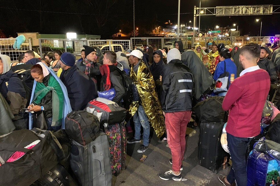Migrantes venezolanos durante la medianoche del domingo intentan cruzar hacia Ecuador por el puente internacional de Rumichaca, fronterizo con Colombia.  / EFE