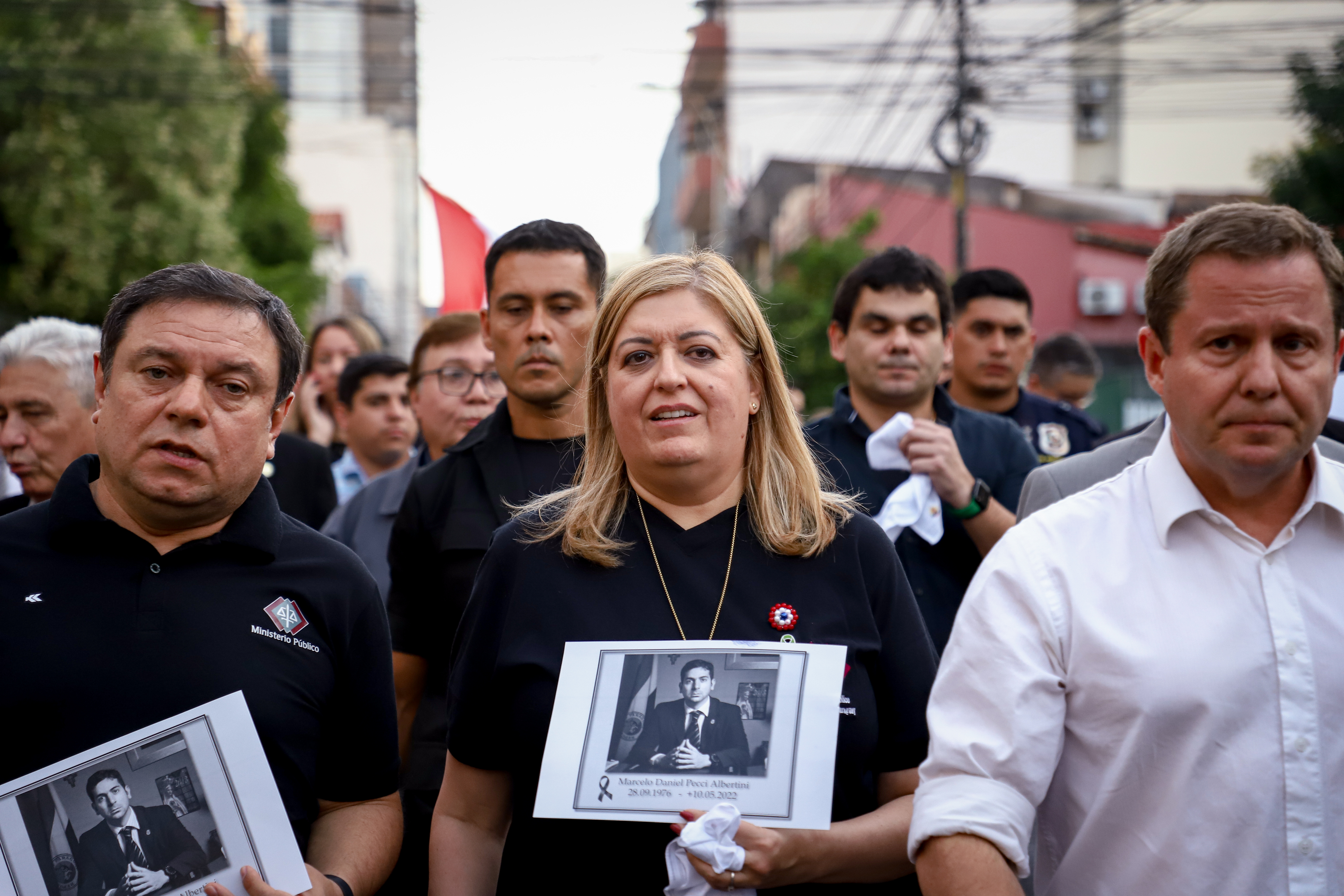 AME9237. ASUNCIÓN (PARAGUAY), 13/05/2022.- Augusto Salas (i), presidente de la Asociación de Agentes Fiscales del Paraguay, junto a Sandra Quiñonez (c), fiscal general del Estado, y centenares de personas se suman este viernes a sendas marchas y un emotivo homenaje al fiscal antimafia Marcelo Pecci, asesinado en Colombia, en Asunción (Paraguay). Funcionarios judiciales encabezados por la fiscal general, Sandra Quiñónez, marcharon desde la sede del Ministerio Público hasta el Panteón de los Héroes, en el centro histórico de Asunción. Hasta ese lugar acudieron, además, manifestantes convocados por exalumnos del colegio San José, donde cursó sus estudios Pecci, quien a sus 45 años era uno de los fiscales más reputados del país. EFE/ Nathalia Aguilar