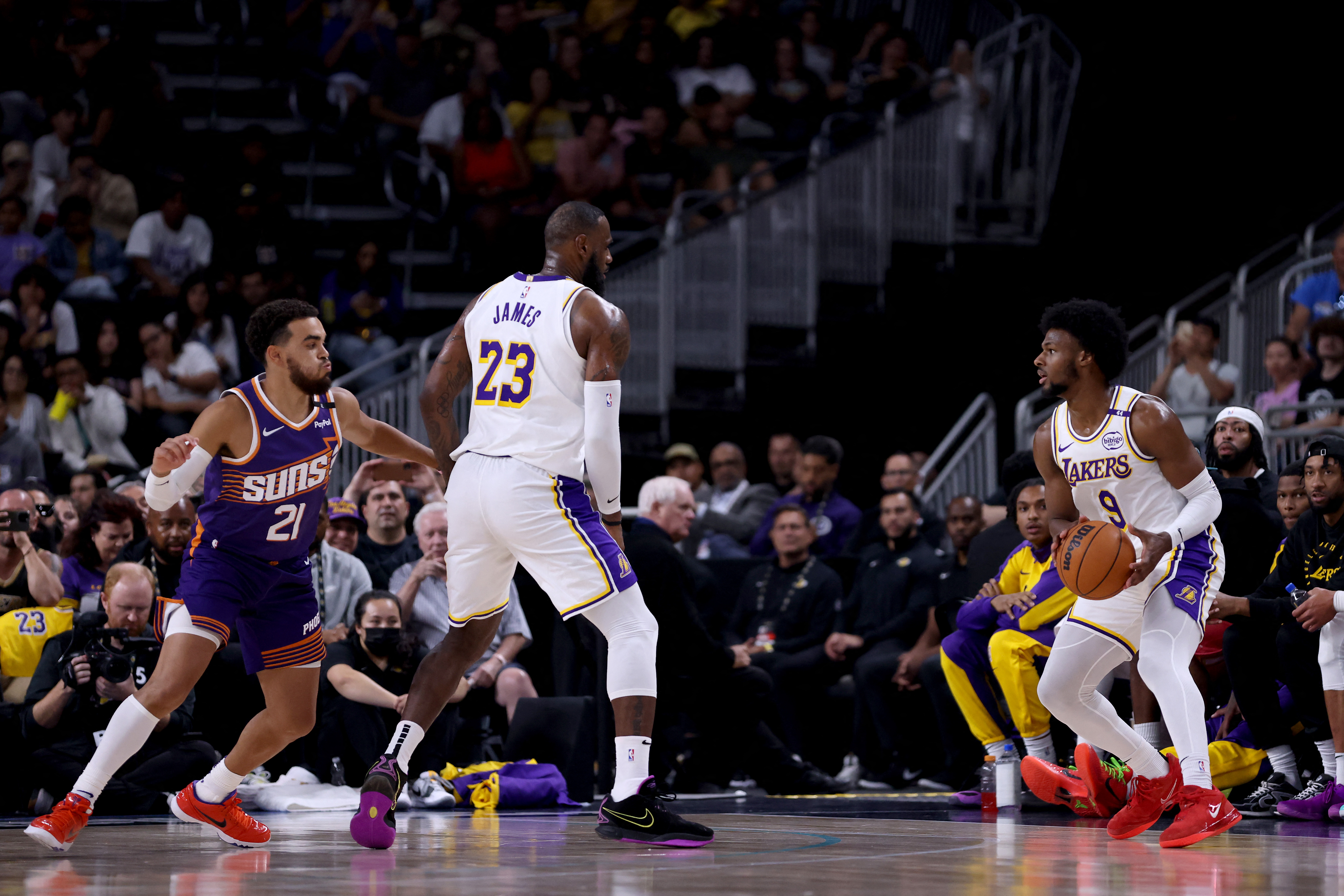 LeBron James (centro) junto a su hijo Bronny James, durante un partido de pretemporada de Los Ángeles Lakers.