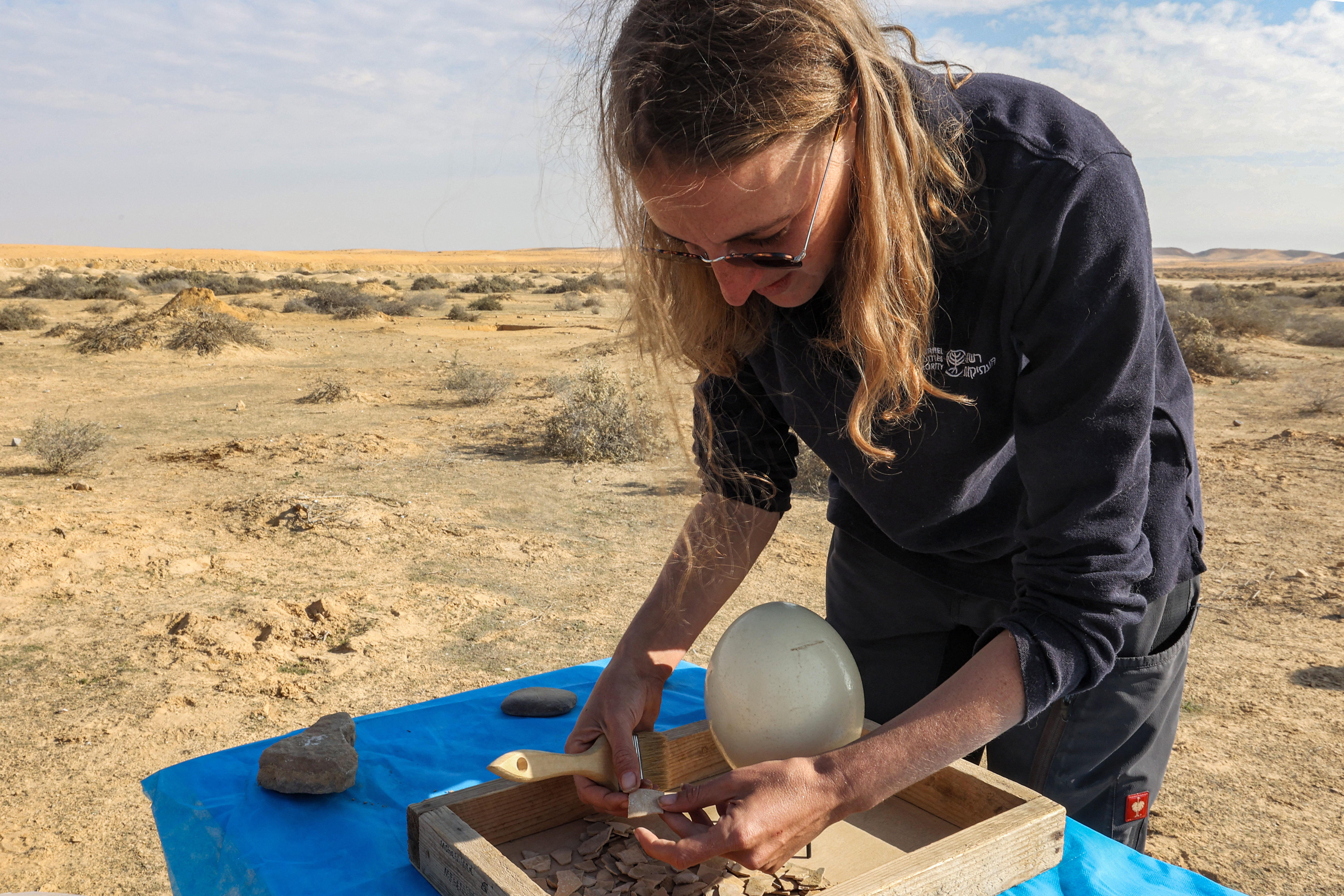 This picture taken on January 12, 2023 shows a view of discovered ostrich egg fragments dating over 4000 years discovered by the Israel Antiquities Authority (IAA) at a site in the dunes near Nitzana along the Israel-Egypt border in the western Negev desert. - Experts say the finds provide insight into the life of the ancient peoples inhabiting the region. The eight crushed eggs were located at a camp site used by nomads "since prehistoric times," said Lauren Davis, the Israel Antiquities Authority excavation director. Their proximity to the fire, alongside stones, flint, tools and pottery sherds, implies that the eggs were to be cooked, said Davis. (Photo by GIL COHEN-MAGEN / AFP)