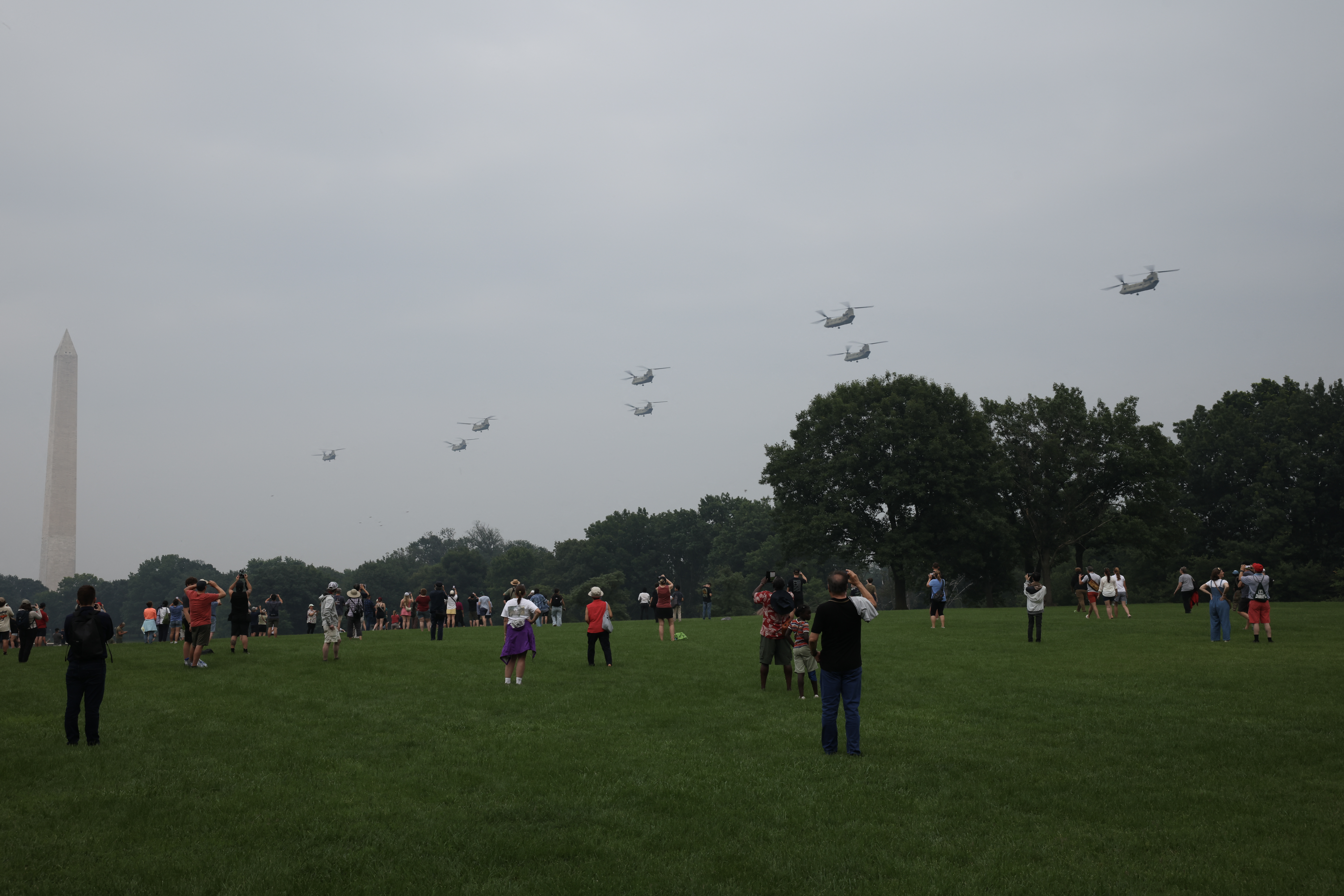 Espectadores ven pasar helicópteros en el desfile por los 250 años del Ejército de Estados Unidos.