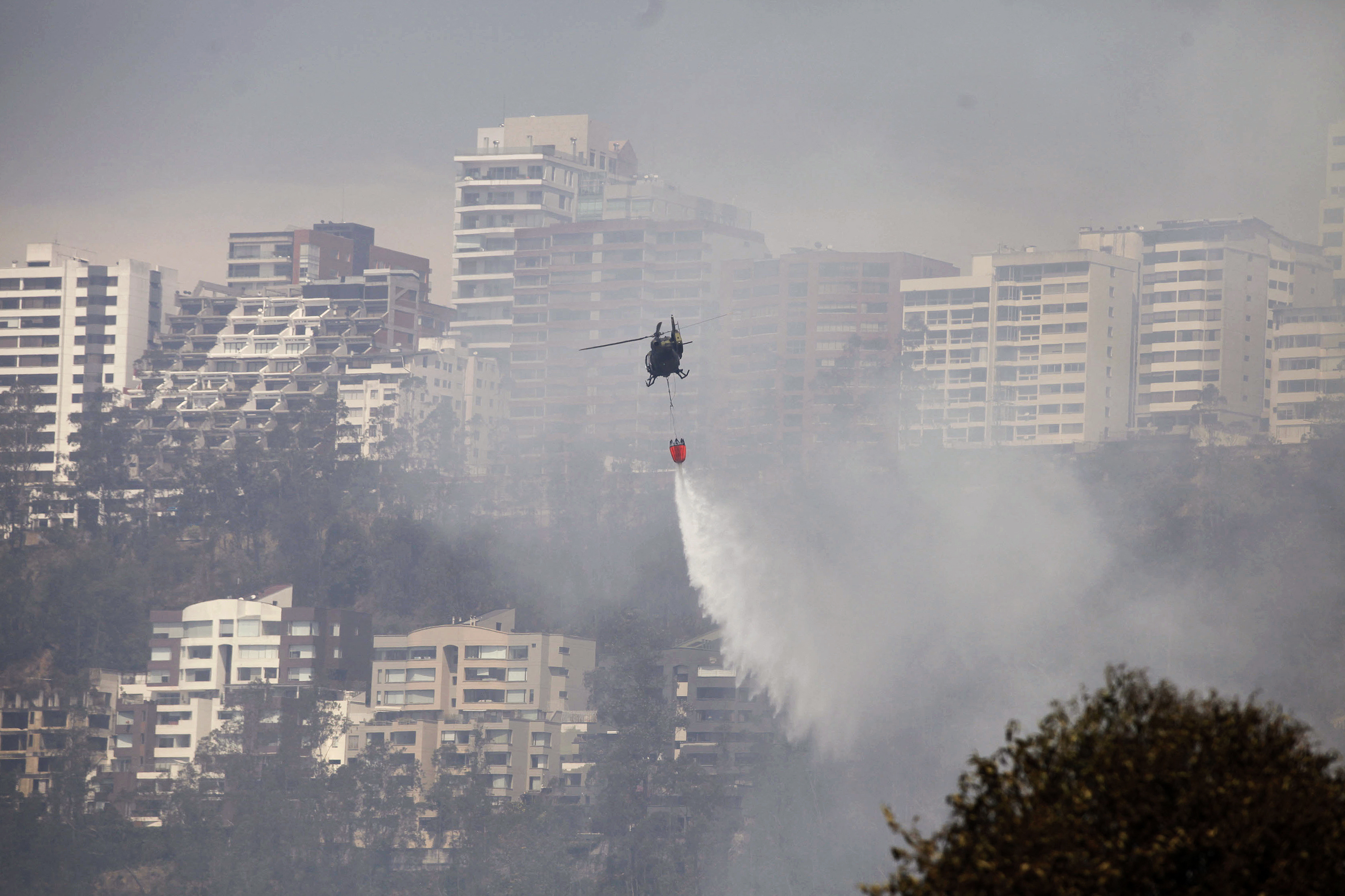 Un helicóptero rocía agua sobre un incendio forestal en una colina en Quito el 25 de septiembre de 2024.