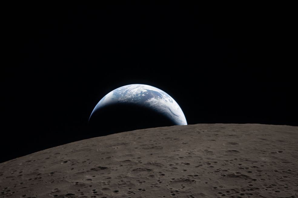 Esta foto es de una puesta de Sol capturada a través de la ventana de la nave espacial Orión. La Tierra se ve azul tenue con brillantes nubes blancas.