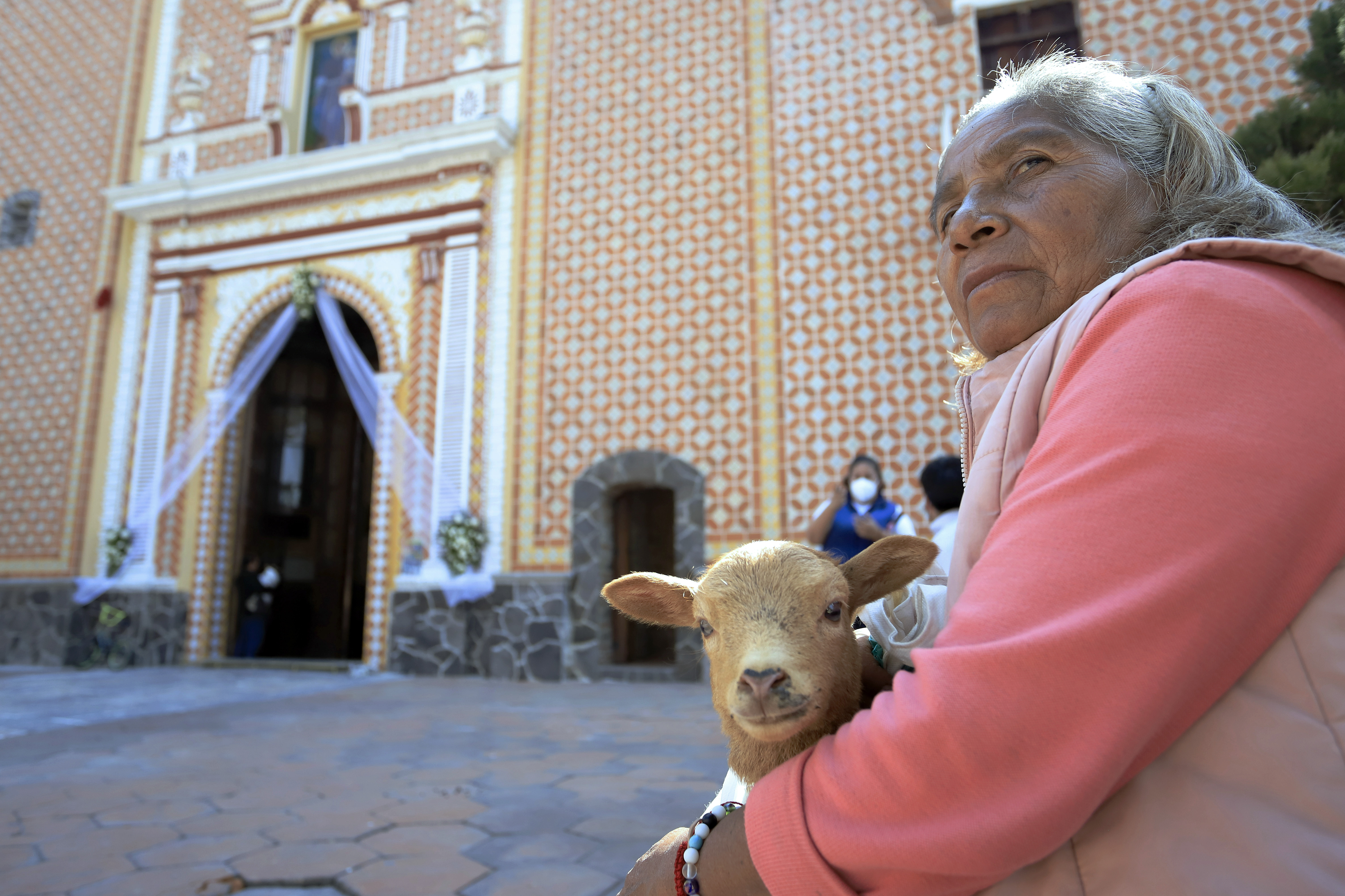 MEX4359. SAN ANDRÉS CHOLULA (MÉXICO), 17/01/2023.- Una mujer lleva a su mascota a bendecir en el marco de los festejos de San Antonio Abad hoy, en el municipio de San Andrés Cholula, estado de Puebla (México). Como si de una pasarela se tratara, cientos de mascotas y animales de campo desfilaron, con sus mejores vestidos, collares y hasta con gafas de sol, por el atrio de la iglesia de San Antonio Abad, quien es recordado como el santo protector de los animales y cuyo santoral se celebra este martes 17 de enero. EFE/Hilda Ríos
