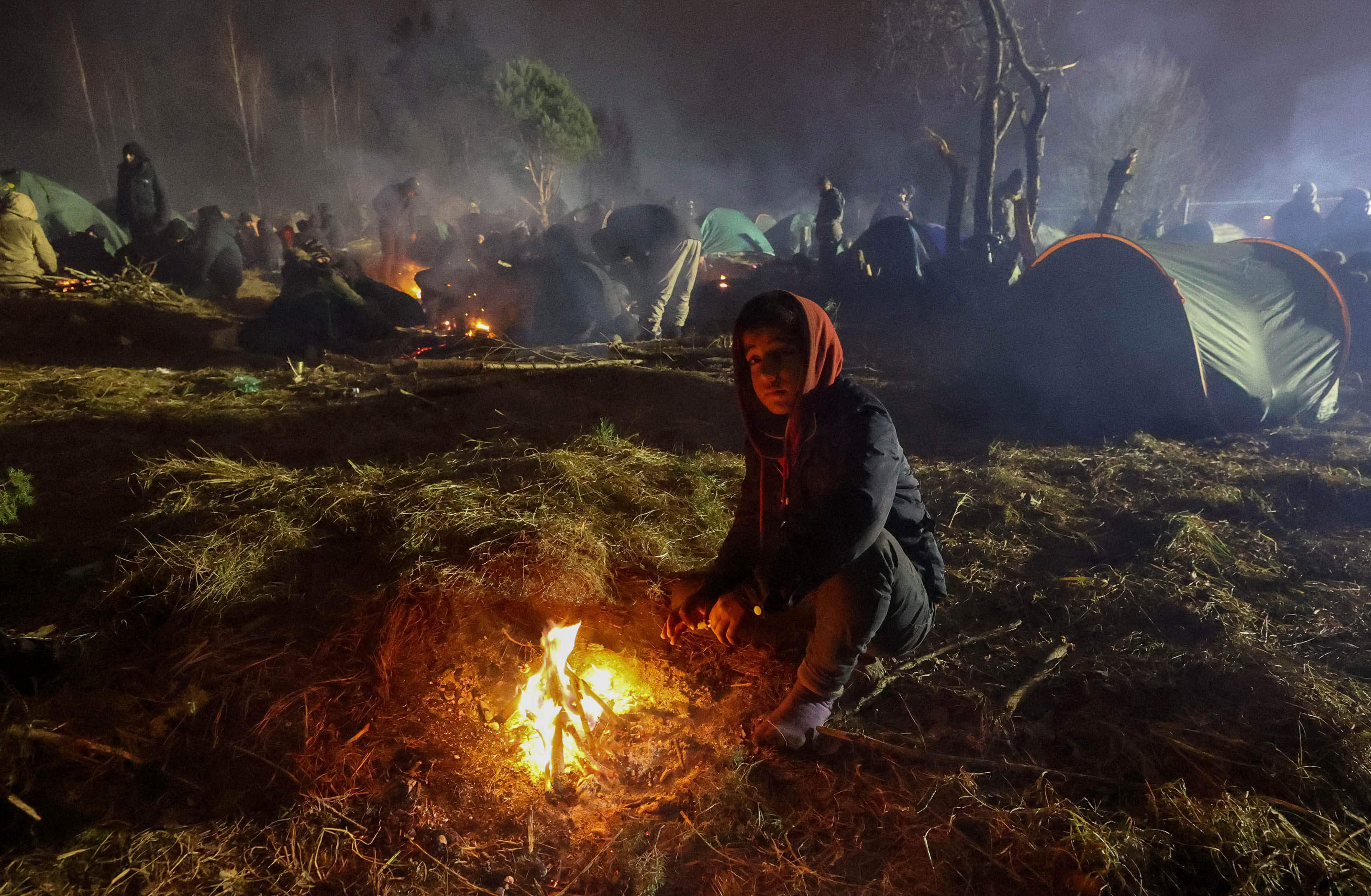 Migrants aiming to cross into Poland camp near the Bruzgi-Kuznica border crossing on the Belarusian-Polish border on November 17, 2021. (Photo by Maxim GUCHEK / BELTA / AFP) / Belarus OUT