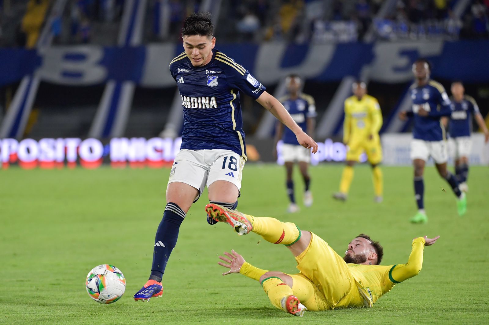 Daniel Ruiz (izq.), de Millonarios, controla un balón.