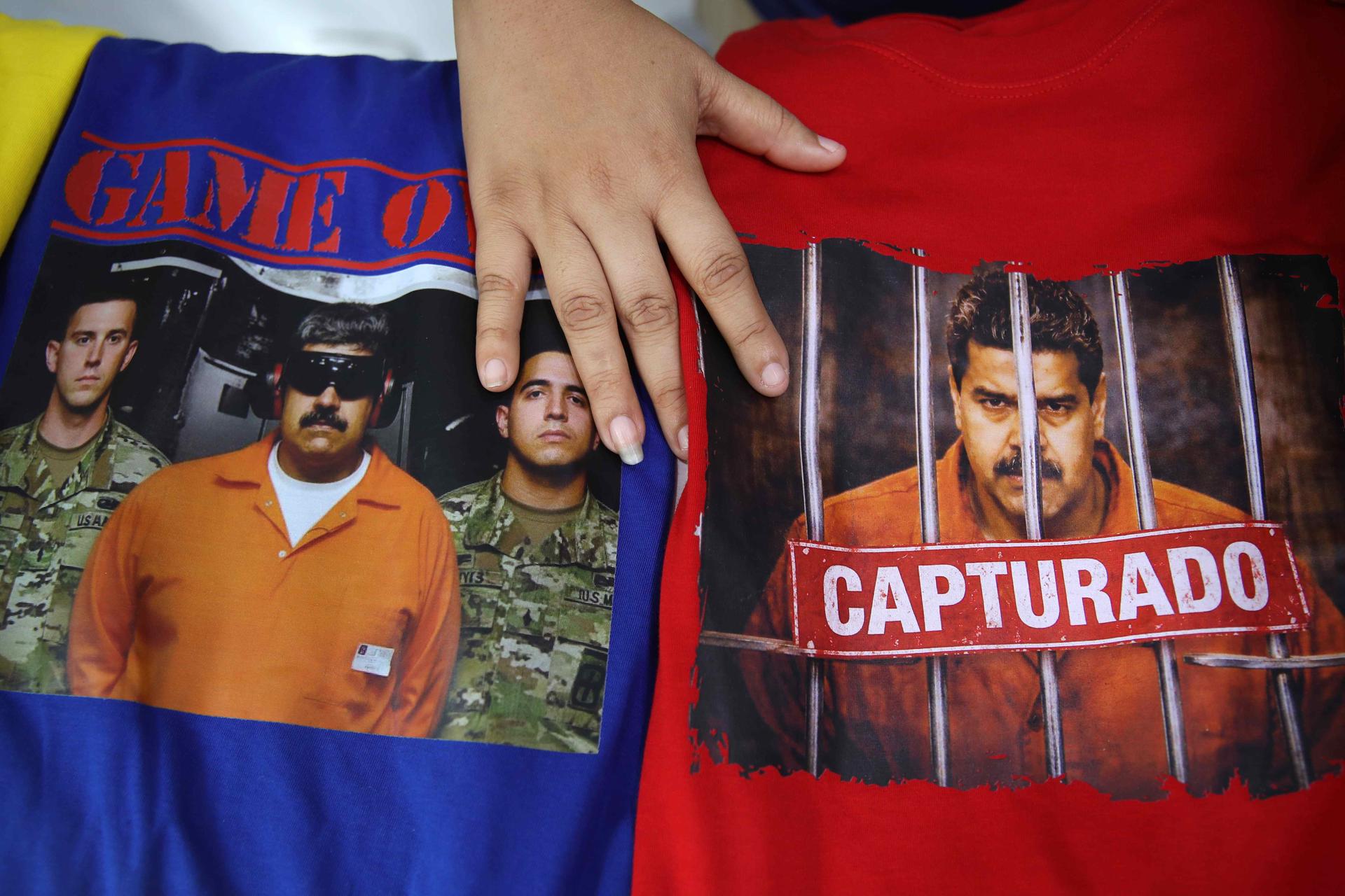 AME2707. LIMA (PERÚ), 06/01/2026.- Fotografía que muestra camisetas con imágenes de la captura del presidente de Venezuela, Nicolás Maduro, este martes, en Lima (Perú). Las imágenes de la captura de Maduro han pasado a estamparse en camisetas y prendas de vestir, diseños que se han puesto de moda entre la comunidad venezolana residente en Perú para celebrar este acontecimiento de su país. EFE/ Paolo Aguilar