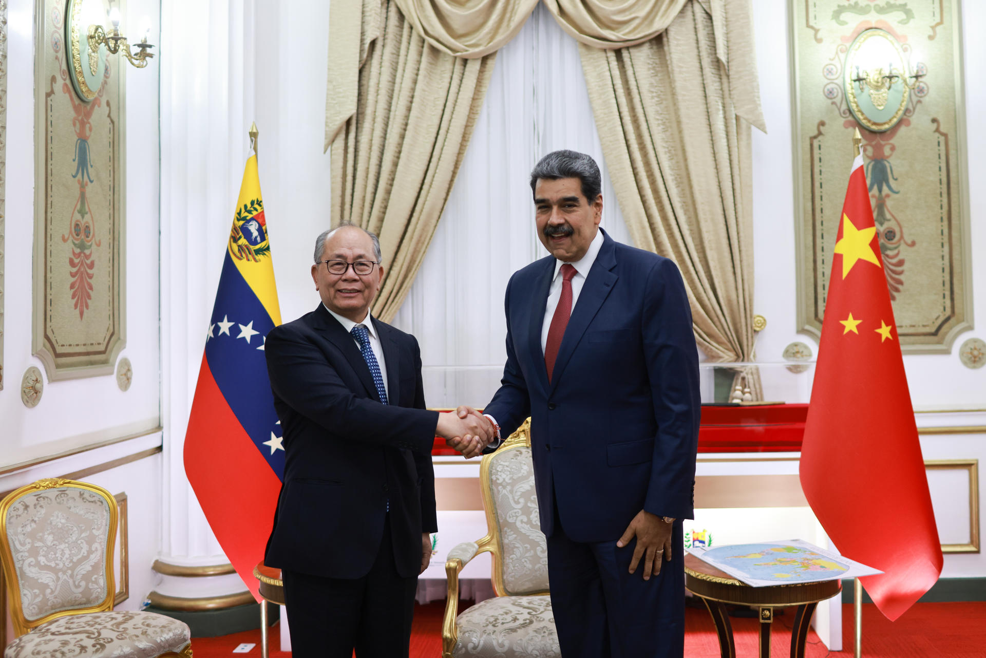 AME1493. CARACAS (VENEZUELA), 02/01/2026.- Fotografía cedida por el Palacio de Miraflores que muestra al presidente de Venezuela, Nicolás Maduro (d), estrechando su mano con el enviado especial de china, Qiu Xiaoqi, durante una reunión este viernes, en Caracas (Venezuela). Maduro celebró la unión "a toda prueba" entre su país y su aliada China, a propósito de la visita de Xiaoqi en momentos e que la nación caribeña enfrenta tensiones con EE.UU. por el despliegue militar de Washington en el mar Caribe. EFE/ Palacio de Miraflores /SOLO USO EDITORIAL/NO VENTAS/SOLO DISPONIBLE PARA ILUSTRAR LA NOTICIA QUE ACOMPAÑA (CRÉDITO OBLIGATORIO)
