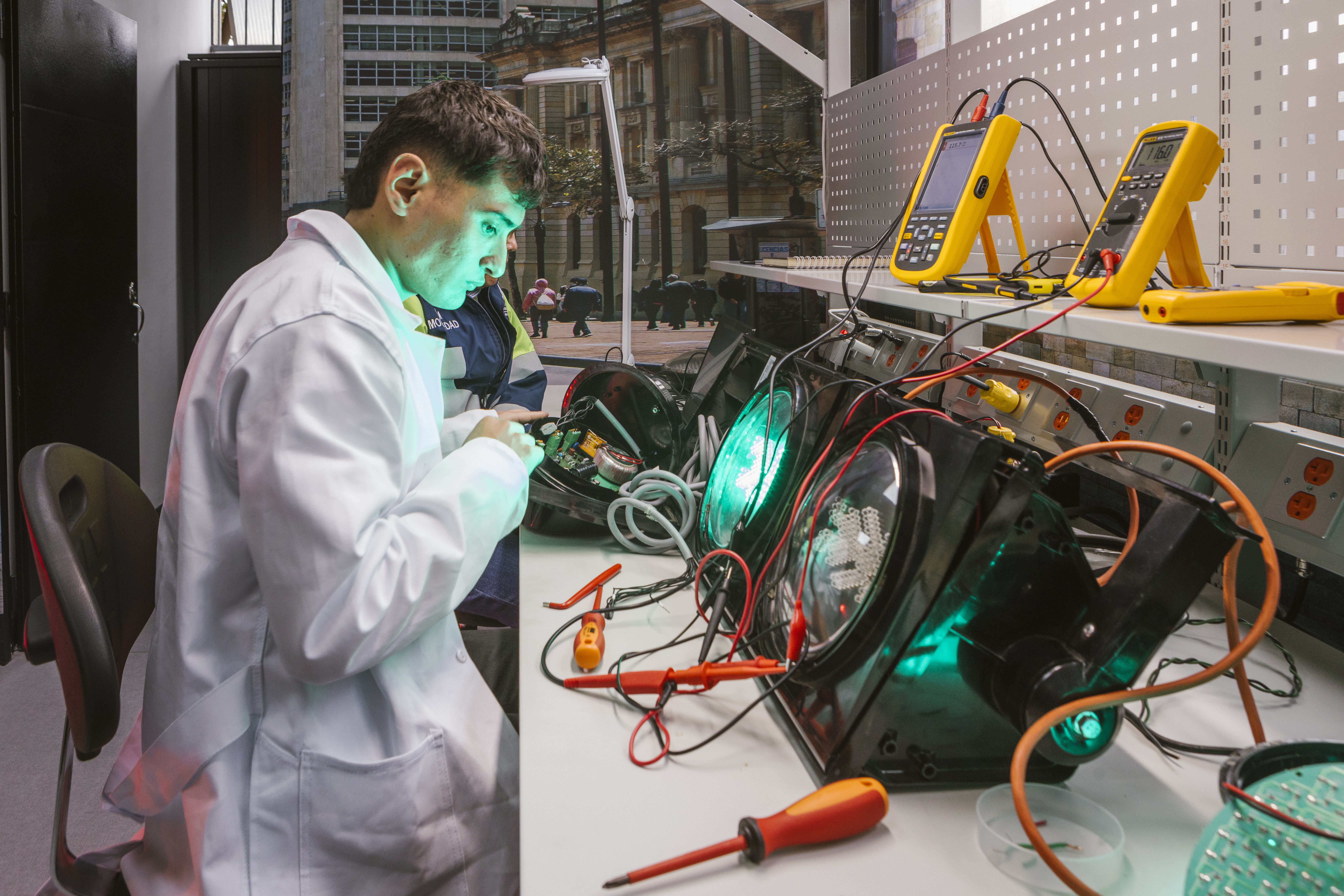 Funcionario trabaja sobre la electrónica de un semáforo en el laboratorio.
