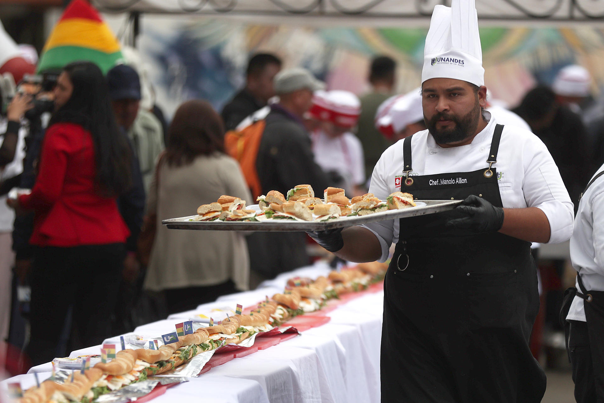 AME6889. LA PAZ (BOLIVIA), 10/10/2025.- Cocineros preparan un sándwich de huevo durante el 'Día Mundial del Huevo' este viernes, en La Paz (Bolivia). Decenas de estudiantes de gastronomía de una universidad en Bolivia consiguieron preparar el sándwich de huevo "más largo" del país, de más de 100 metros de longitud, con el objetivo de impulsar el consumo de este alimento. EFE/ Luis Gandarillas
