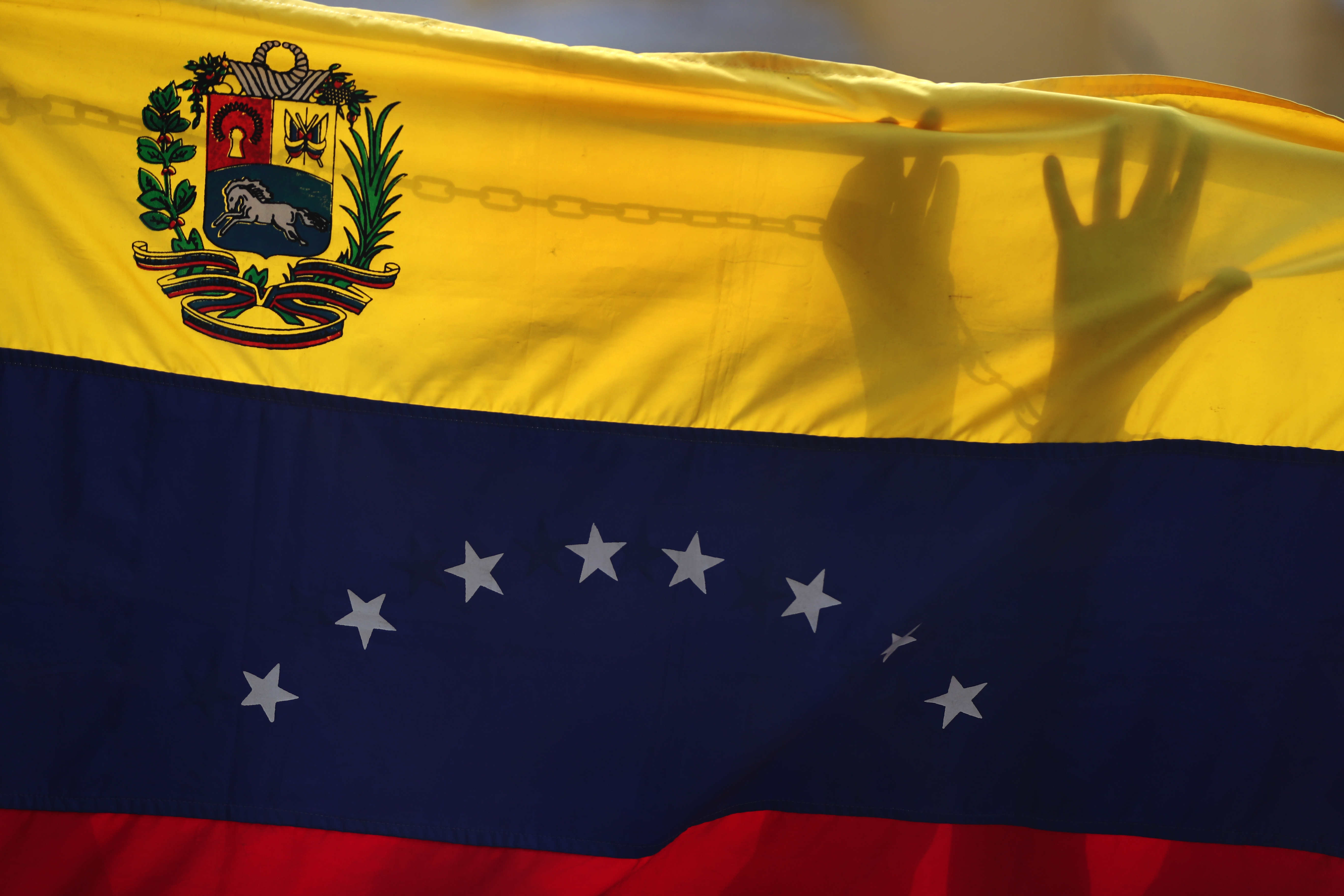 -FOTODELDÍA- AME7850. LIMA (PERÚ), 15/04/2024.- Fotografía de una bandera de Venezuela durante una protesta de ciudadanos venezolanos residentes en Perú contra los "obstáculos impuestos" por las autoridades electorales que, según denuncian, les impiden registrarse como votantes para las próximas elecciones, este lunes frente a la embajada de Venezuela en Lima (Perú). Aura Margarita Riera, una de las mujeres que se concentró frente a la delegación diplomática, explicó a EFE que lleva siete años viviendo en Perú y no puede votar, porque tiene carnet de extranjería bajo la calidad migratoria especial. "Ellos (el chavismo) creen que están atornillados, pero todo tiene un destornillador que saca el tornillo; algún día, en algún momento", dijo Riera sobre la situación en Venezuela. EFE/ Paolo Aguilar