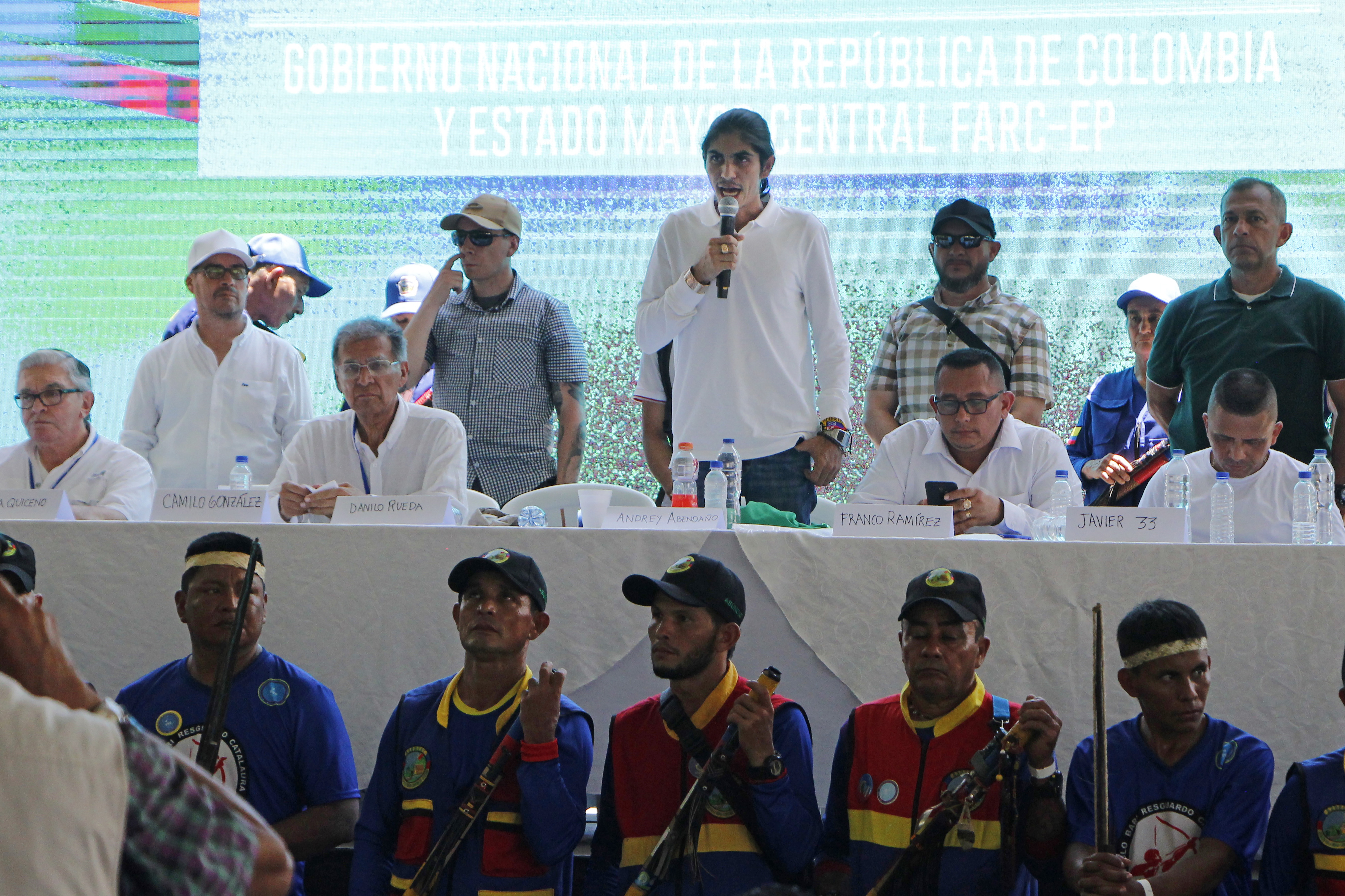 AME5516. TIBÚ (COLOMBIA), 08/10/2023.- El vocero de la delegación del EMC, Andrey Avendaño (c), habla hoy durante el acto en el que las delegaciones del Gobierno y del Estado Mayor Central (EMC), principal disidencia de las FARC, instalan la mesa de diálogo y el arranque del cese al fuego bilateral, en el municipio de Tibú, en la convulsa región del Catatumbo (Colombia). El EMC, disidencia formada antes de la firma de la paz con las FARC, agrupa a unas 3.400 personas en varios frentes liderados por alias "Iván Mordisco". Este grupo ya había pactado un cese al fuego con el Gobierno a principios de año que se iba a extender hasta junio, pero fue roto de forma parcial en mayo en cuatro departamentos después de que las disidencias asesinaran a cuatro menores indígenas a los que antes habían reclutado. EFE/ Mario Caicedo
