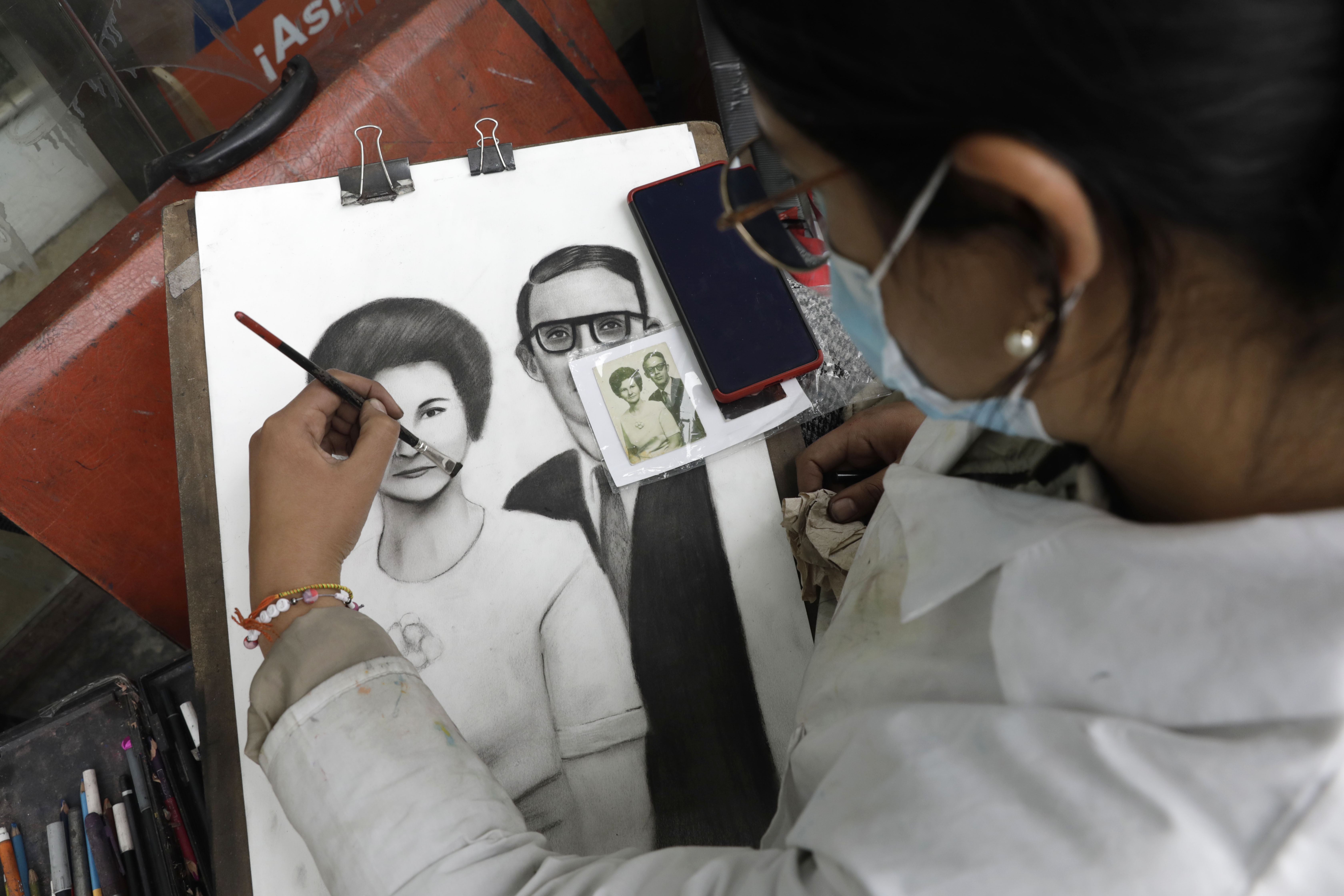 ACOMPAÑA CRÓNICA: COLOMBIA ARTE BOG400. BOGOTÁ (COLOMBIA), 10/07/2022.- Fotografía fechada el 8 de julio de 2022 que muestra a la artista Andrea Durán mientras trabaja pintando retratos en las calles de Bogotá (Colombia). Músicos, estatuas humanas, escultores y pintores, entre otros, se han adueñado de las calles del centro de Bogotá para demostrar que el arte es de todos y para dignificar los trabajos que llenan de vida las arterias de la ciudad desde un programa que busca visibilizar y darles el respeto que merecen. EFE/ Carlos Ortega
