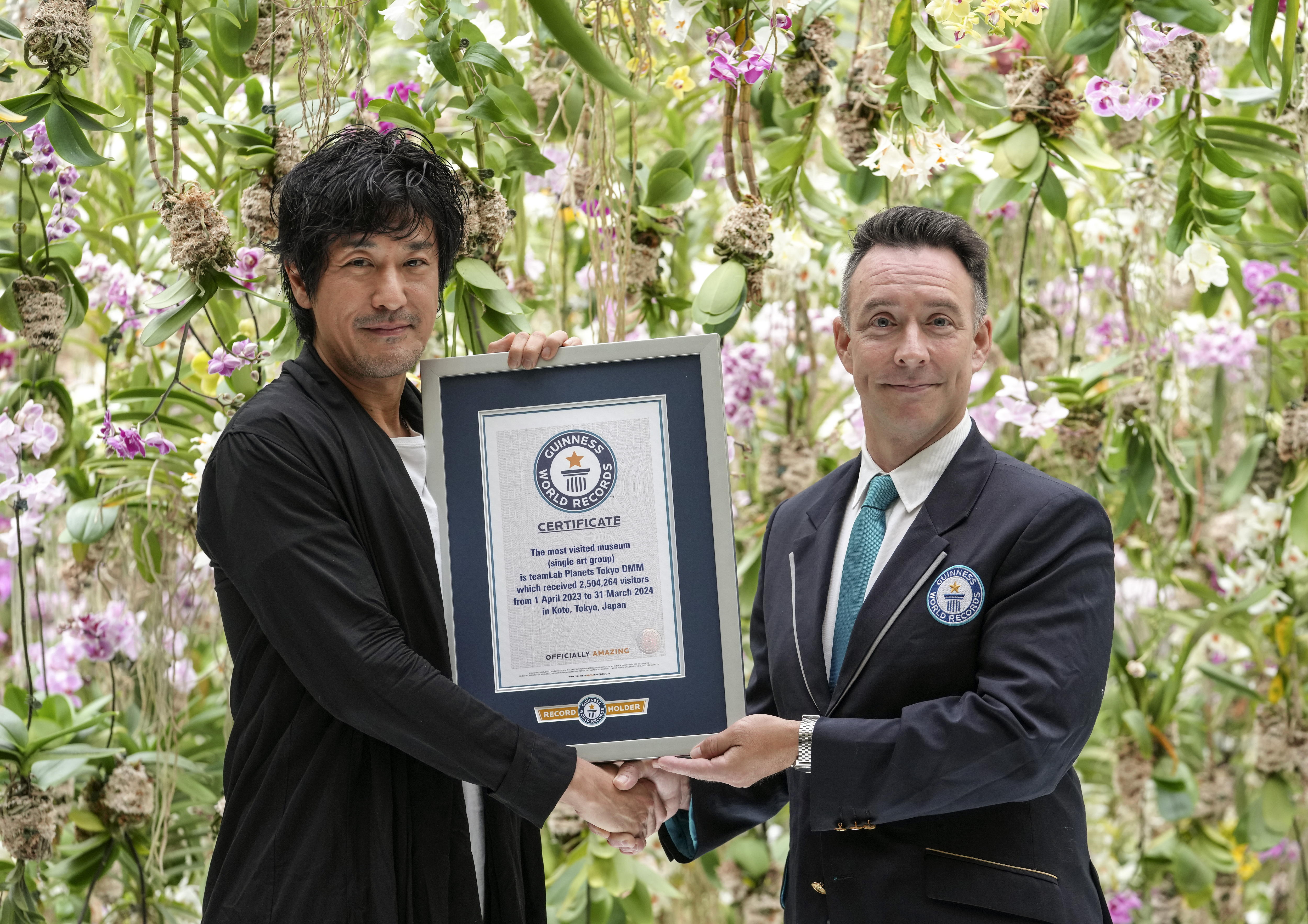 Tokyo (Japan), 10/07/2024.- TeamLab Founder Toshiyuki Inoko (L) receives the Guinness World Records certification during the official certification ceremony at the Floating Flower Garden of teamLab Planets TOKYO DMM in Tokyo, Japan, 10 July 2024. TeamLab Planets TOKYO DMM, which recorded a total of 2,504,264 visitors from 01 April 2023 to 31 March 2024, was recognized by Guinness World Records as the most visited museum (single art group) in the world. (Japón, Tokio) EFE/EPA/KIMIMASA MAYAMA