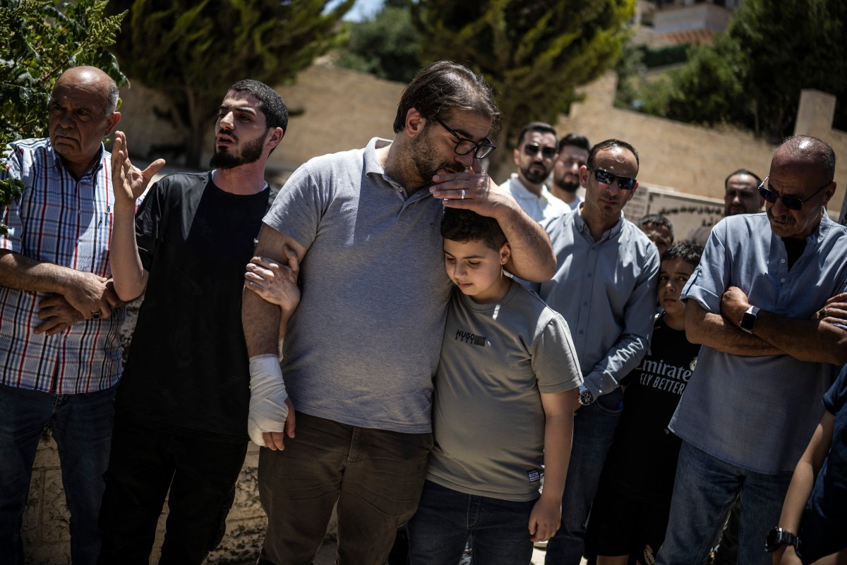 Fahd Abou Haikal, un palestino, consuela a su hijo mayor, Kinan Abou Haikal, tras enterrar a su bebé de siete meses, Sam Fahd Abou Haikal, en Hebrón, en la Cisjordania ocupada, el 6 de junio de 2026.